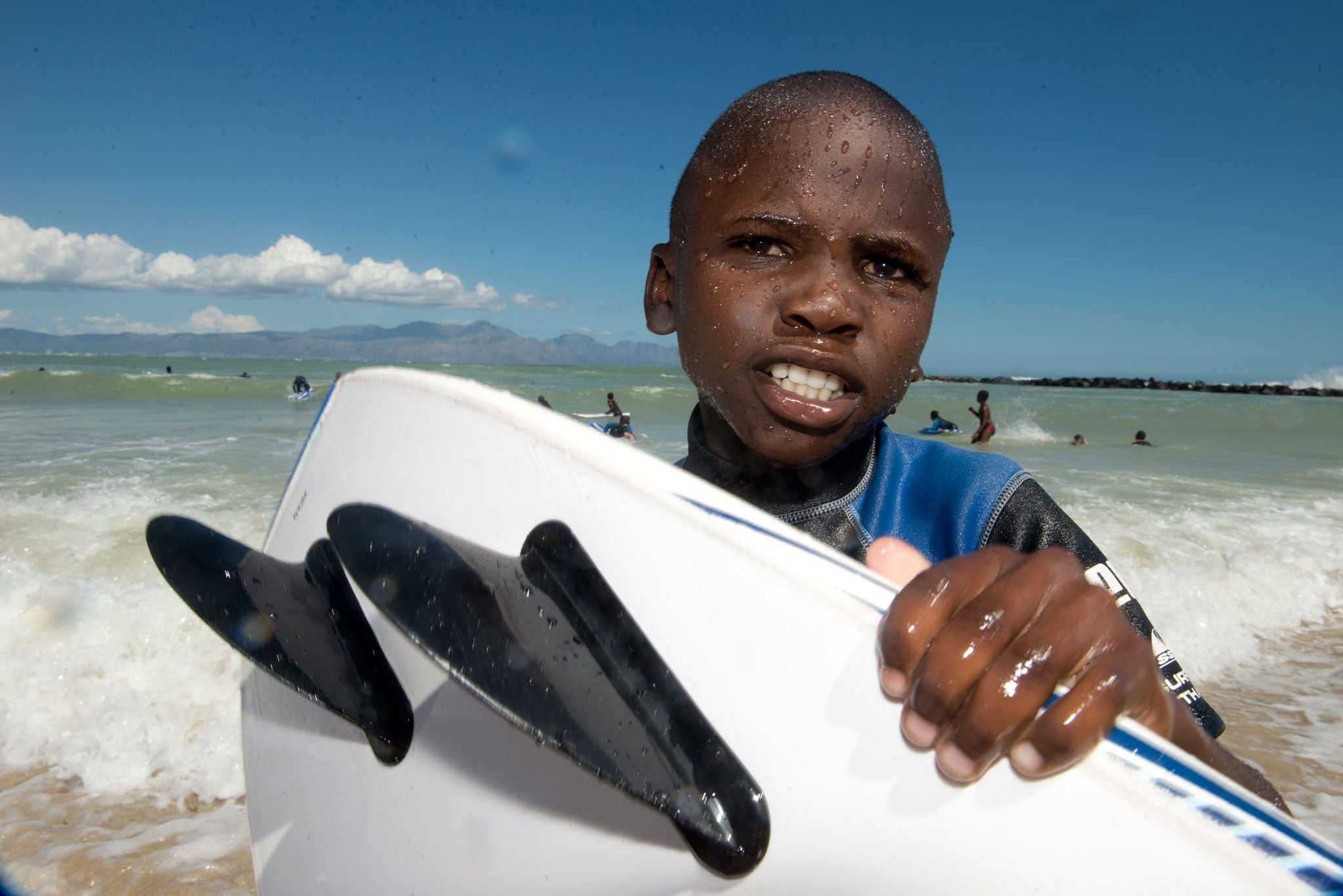 Aphelele Sikaji learning to surf at Monwabisi