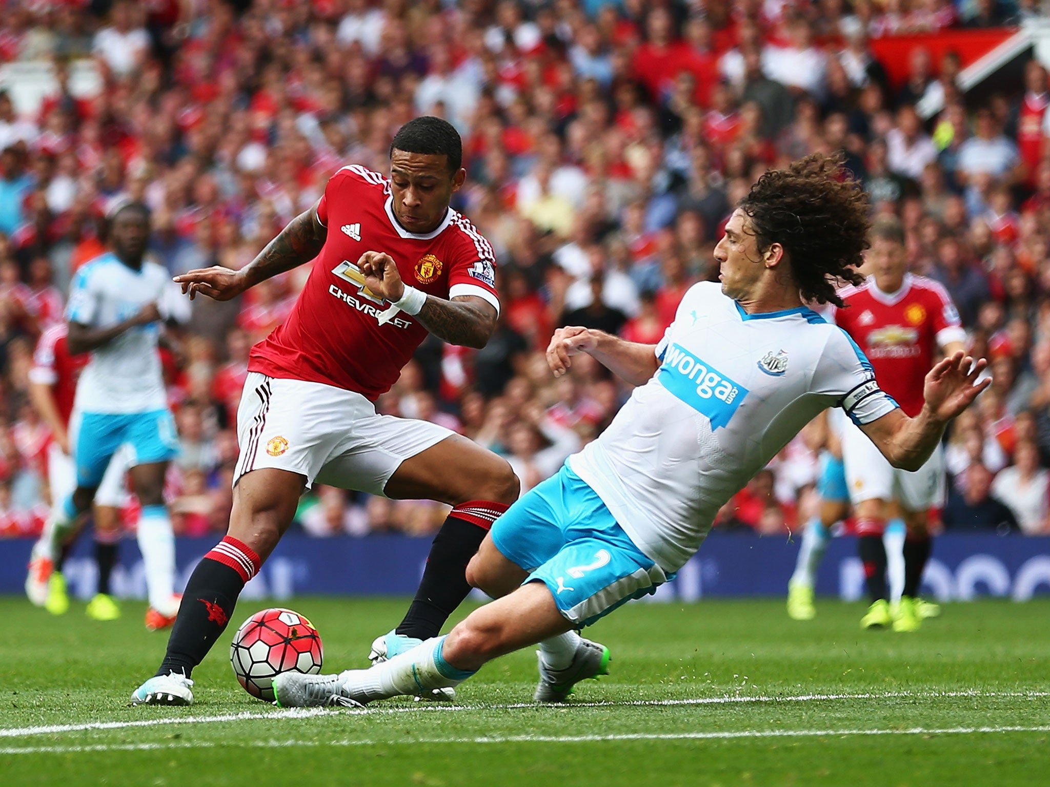 Newcastle defender Fabricio Coloccini tackles Memphis Depay