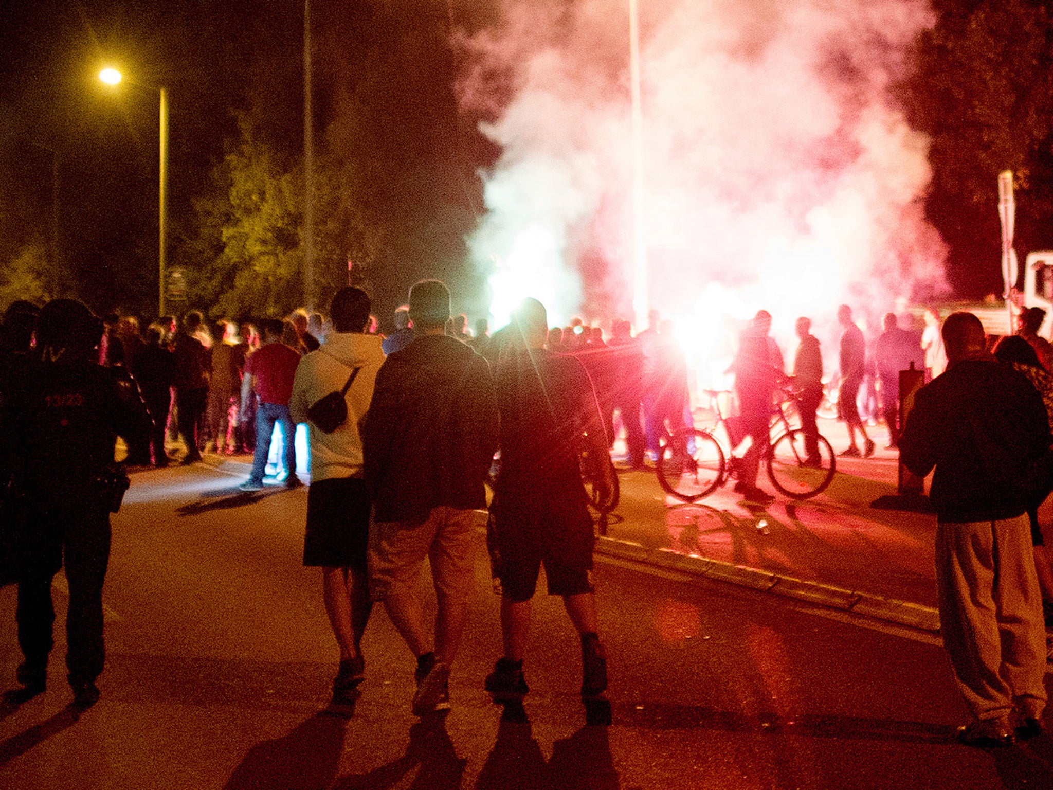 Police stand beside demonstrators outside a former DYI market that has been converted into a shelter for asylum seekers in Heidenau, south of Dresden