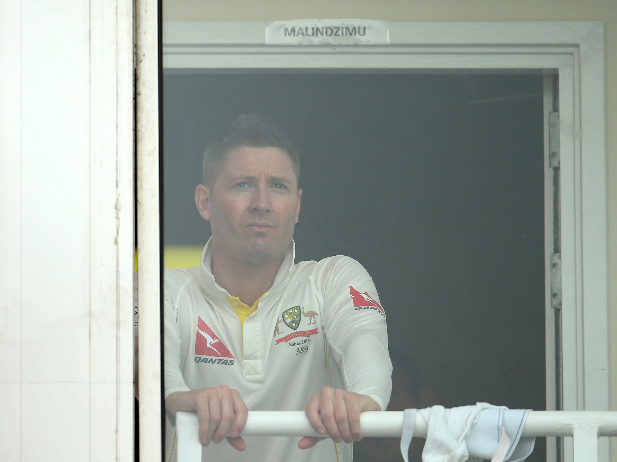 Michael Clarke of Australia looks on from the change rooms after rain stopped play during day four