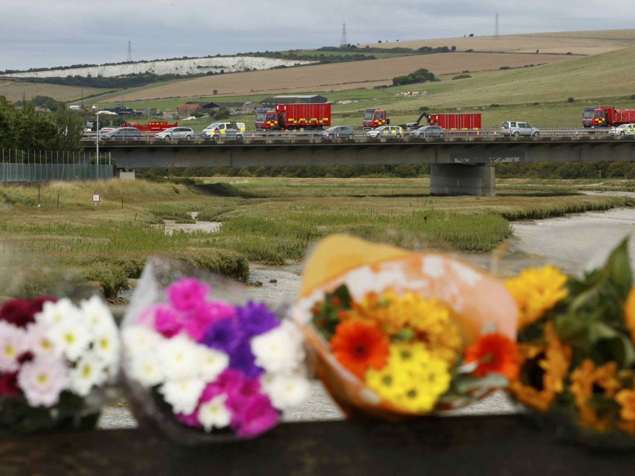 Floral tributes are left near the site where a Hawker Hunter fighter jet crashed onto the A27 road at Shoreham near Brighton, Britain August 23, 2015. A jet aircraft ploughed into several cars on a busy road near an airshow in southern England on Saturday, killing at least seven people, police said.