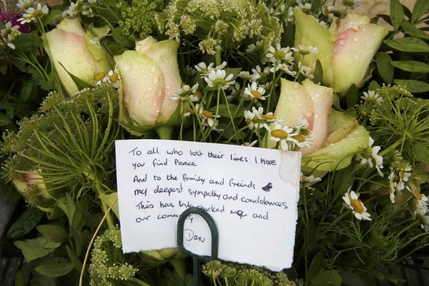 A message is seen on a floral tribute left near the site of the crash (Image: Reuters)