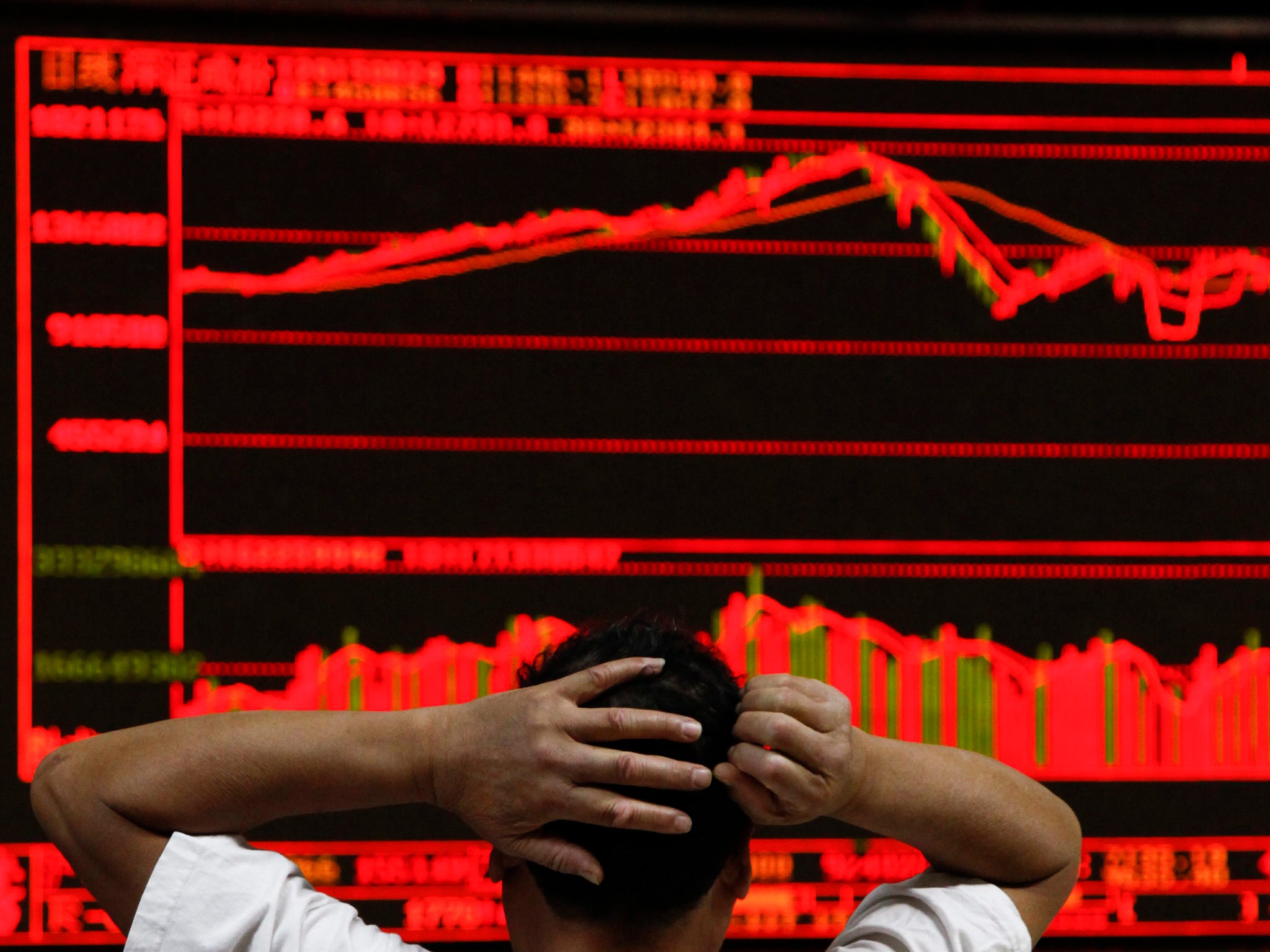 An investor monitors stock data on an electronic board at a securities brokerage house in Beijing, China,