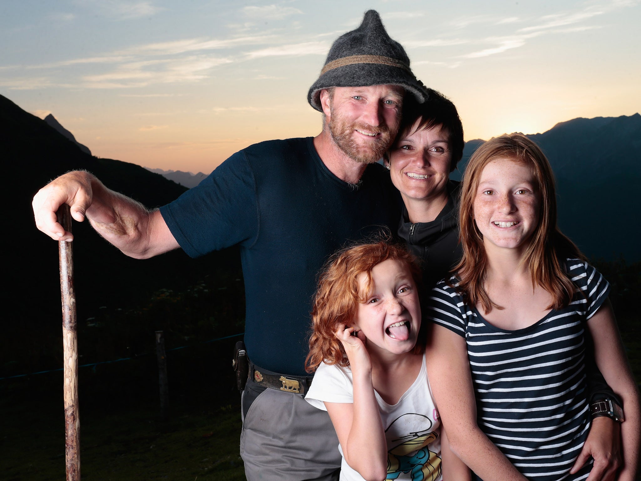 Alpine cattle herder Martin Riedmann (L), his wife Veronica (2R) and their daughters Selina (R) and Sabrina pose for a picture in front of alpine dairy Alpe Albona in the Vorarlberg mountain range of western Tyrol