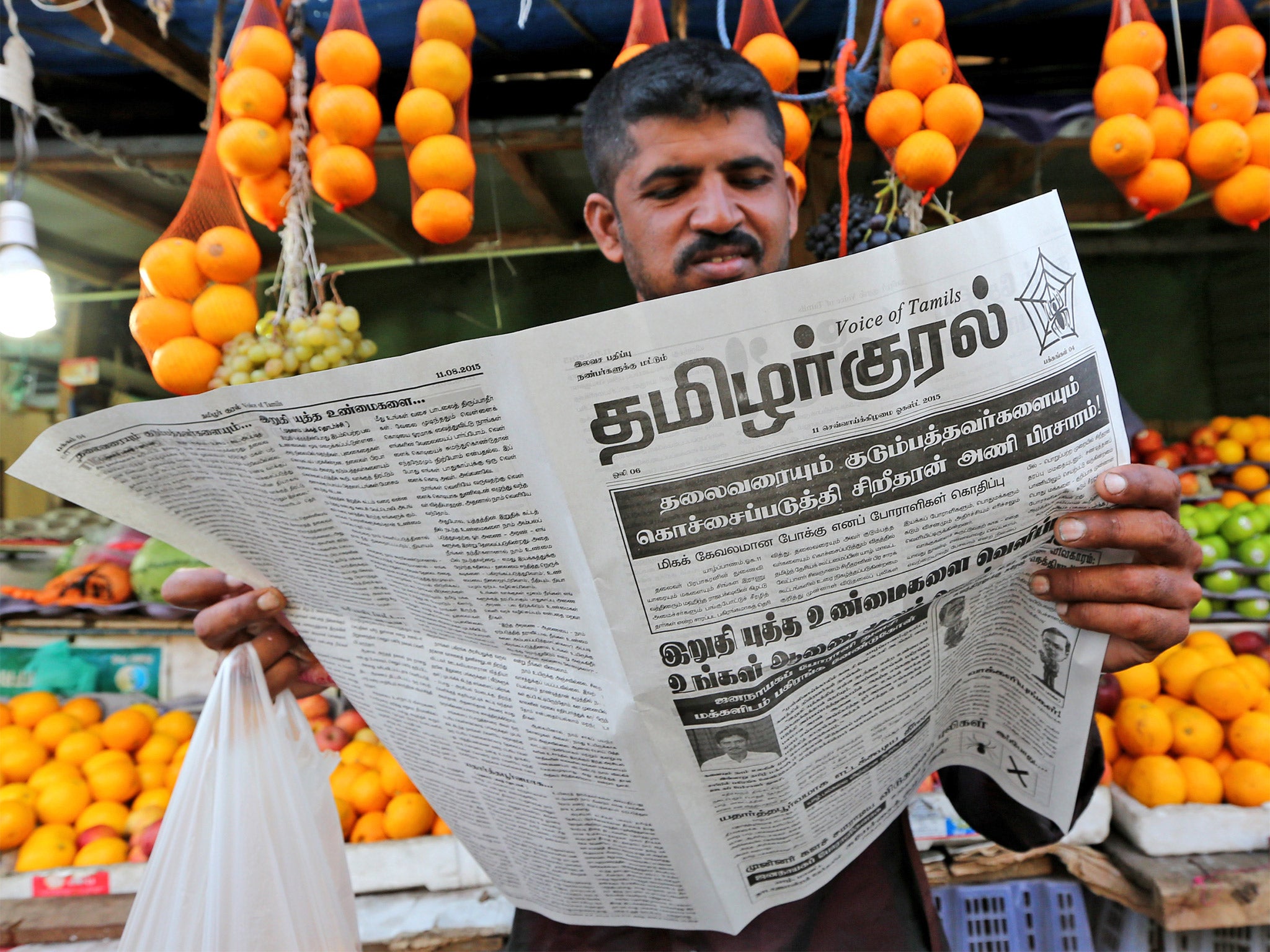 A Tamil supporter reads the party's campaign paper (Getty)