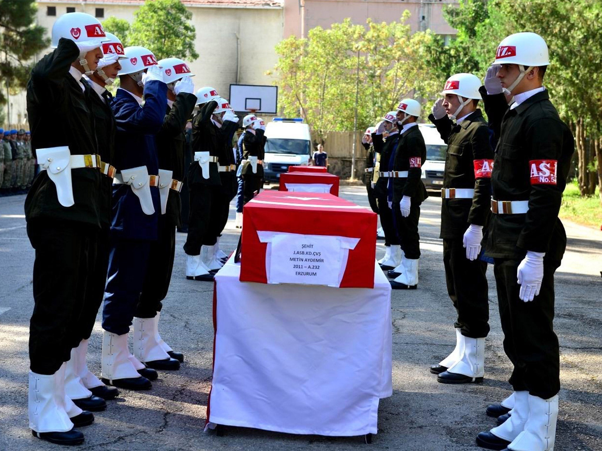 Turkish soldiers salute next to the flag-covered coffins of three soldiers killed during the clashes with Kurdish rebels last week, during a ceremony in Diyarbakir