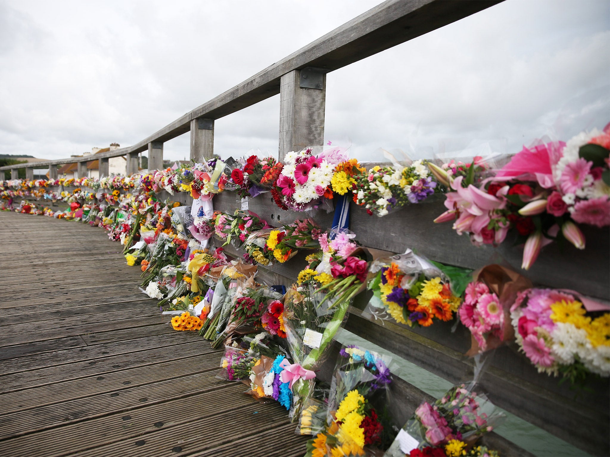 Floral tributes to victims of the crashed Hawker Hunter fighter jet line a bridge in Shoreham