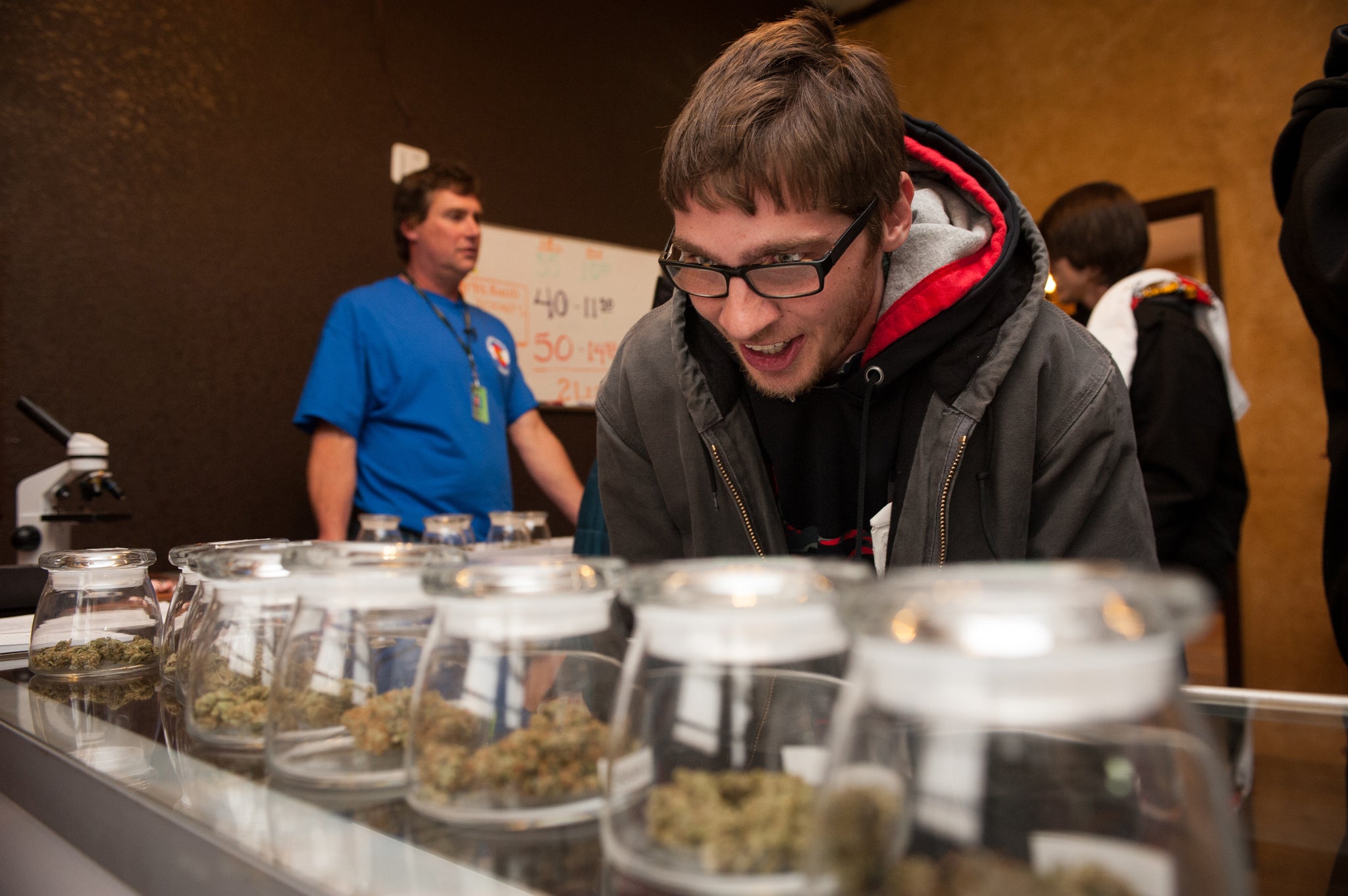 A man selects strains of cannabis in a Colorado cannabis dispensary, just hours after the sale and recreational use of the drug was legalised in the state