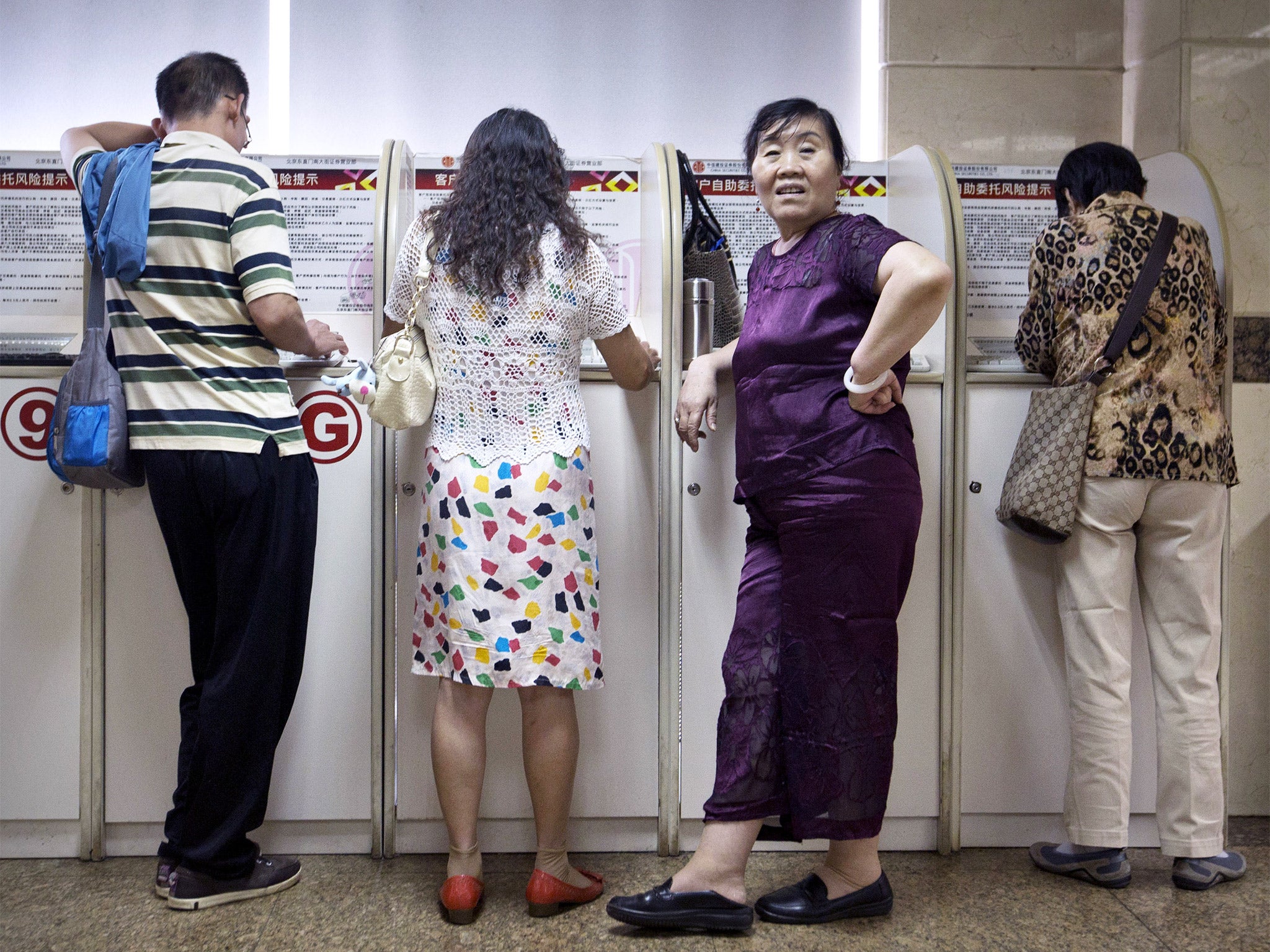 Chinese investors monitor stock prices at a brokerage house in Beijing on Tuesday