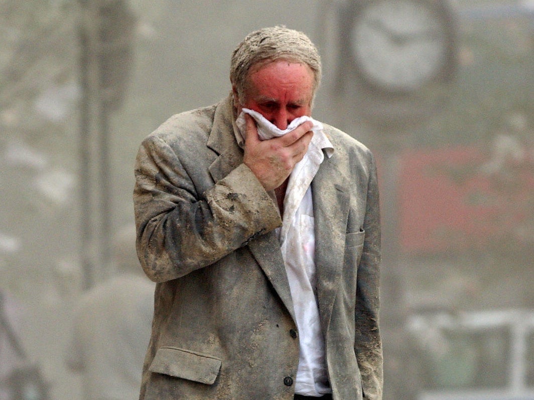 Edward Fine covering his mouth as he walks through the debris