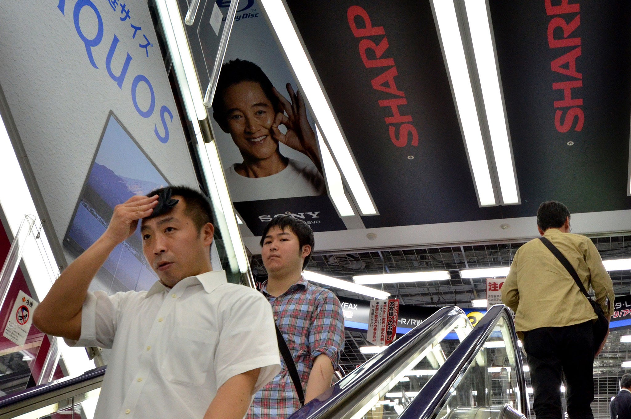 People ride an escalator in Toyko, Japan