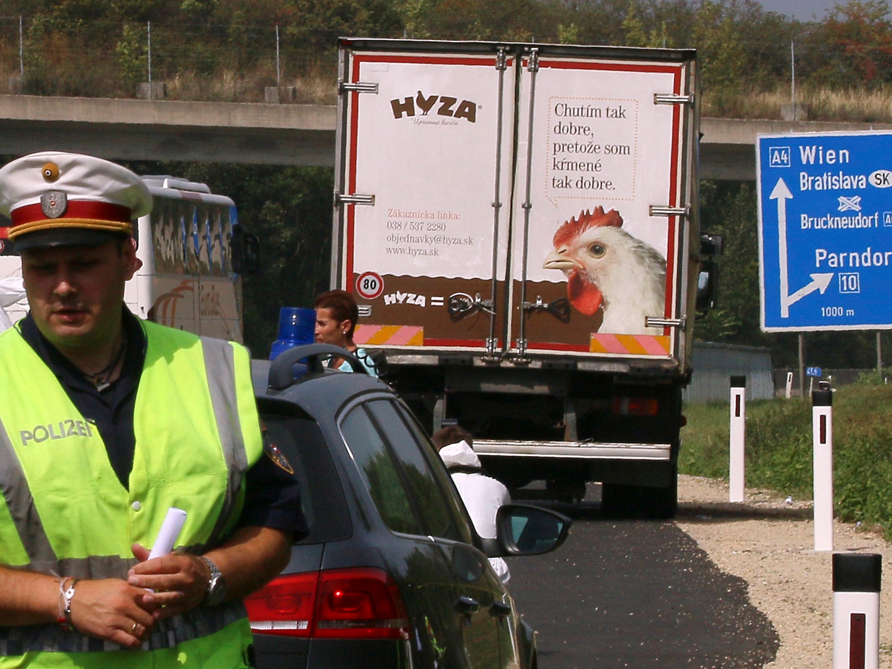 Police stand in front of a truck parked on the shoulder of the highway A4 near Parndorf south of Vienna