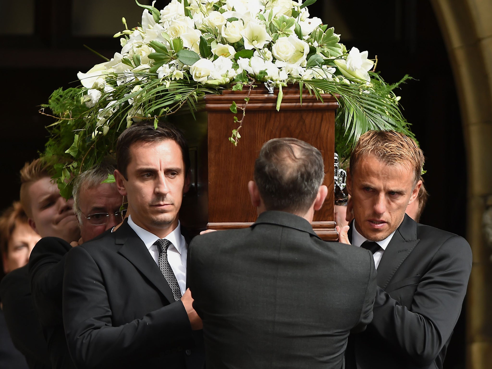 Gary (left) and Phil Neville (right) carry their fathers coffin out of Bury Parish Church in Greater Manchester