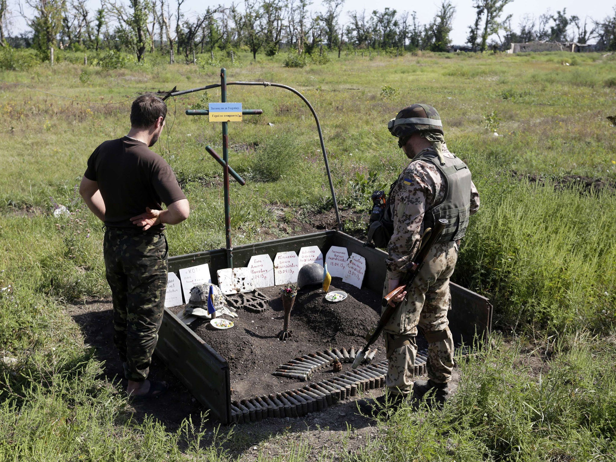 Ukrainian soldiers stand by a memorial for colleagues who died in fighting with pro-Russian rebels in the Donetsk area