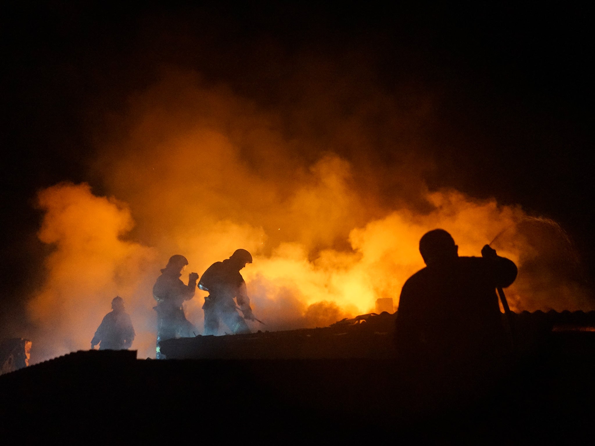 Firefighters extinguish a blaze at a house destroyed by night-long shelling in Donetsk