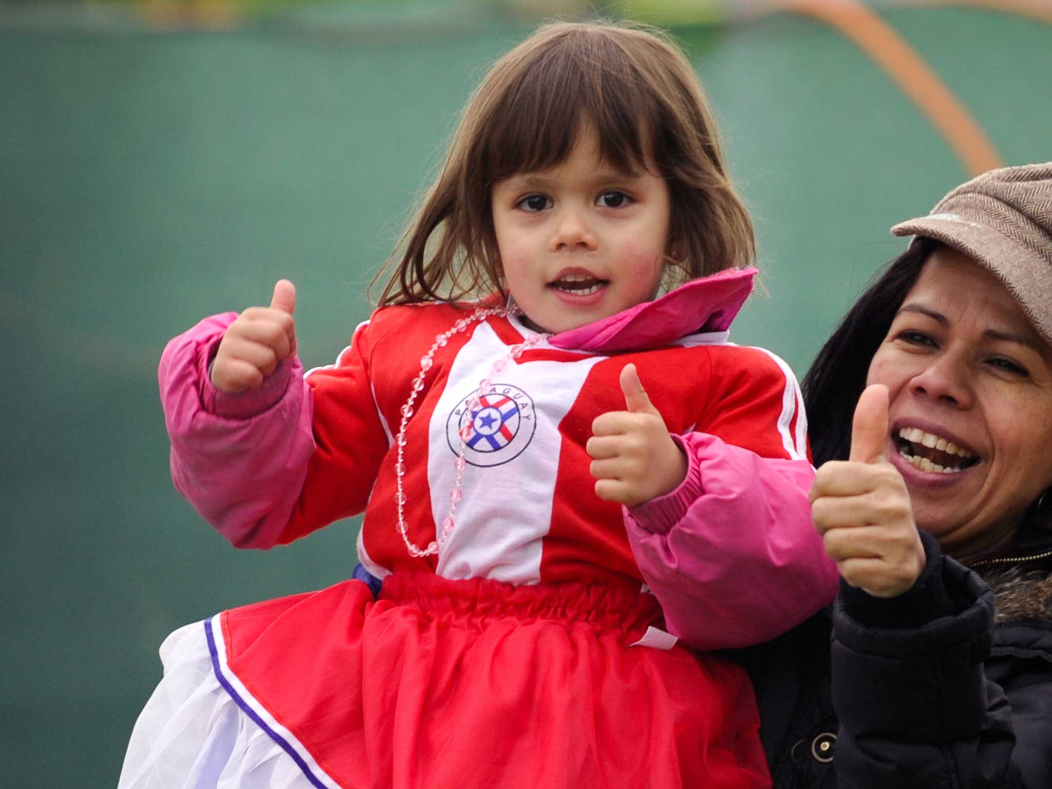 A young girl smiles as she wears Paraguay's flag as a dress