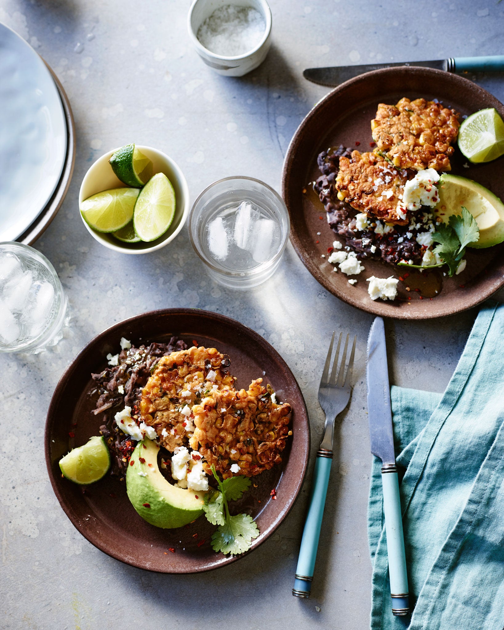 Sweetcorn fritters with avocado, chipotle refried beans, tomato and coriander salad