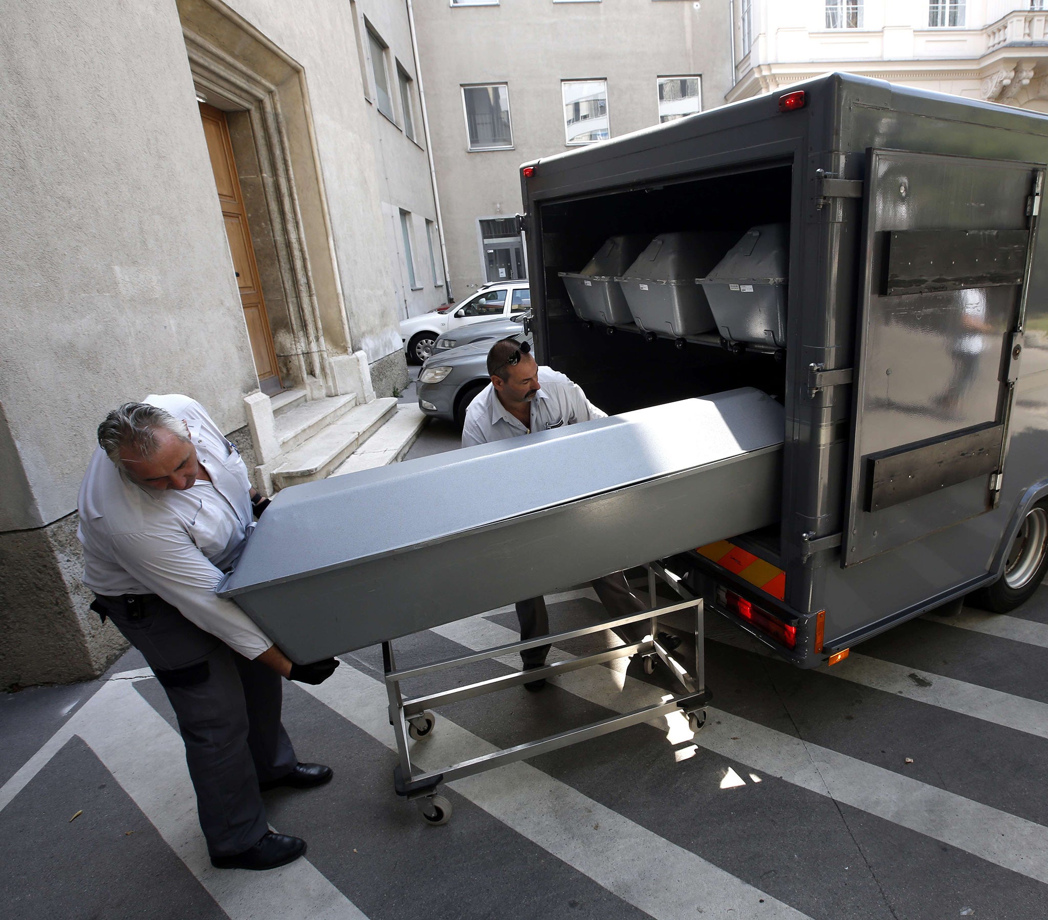 Coffins containing the bodies of migrants found dumped on an Austrian motorway this week are unloaded at the forensics institute in Vienna yesterday. Three people have been arrested