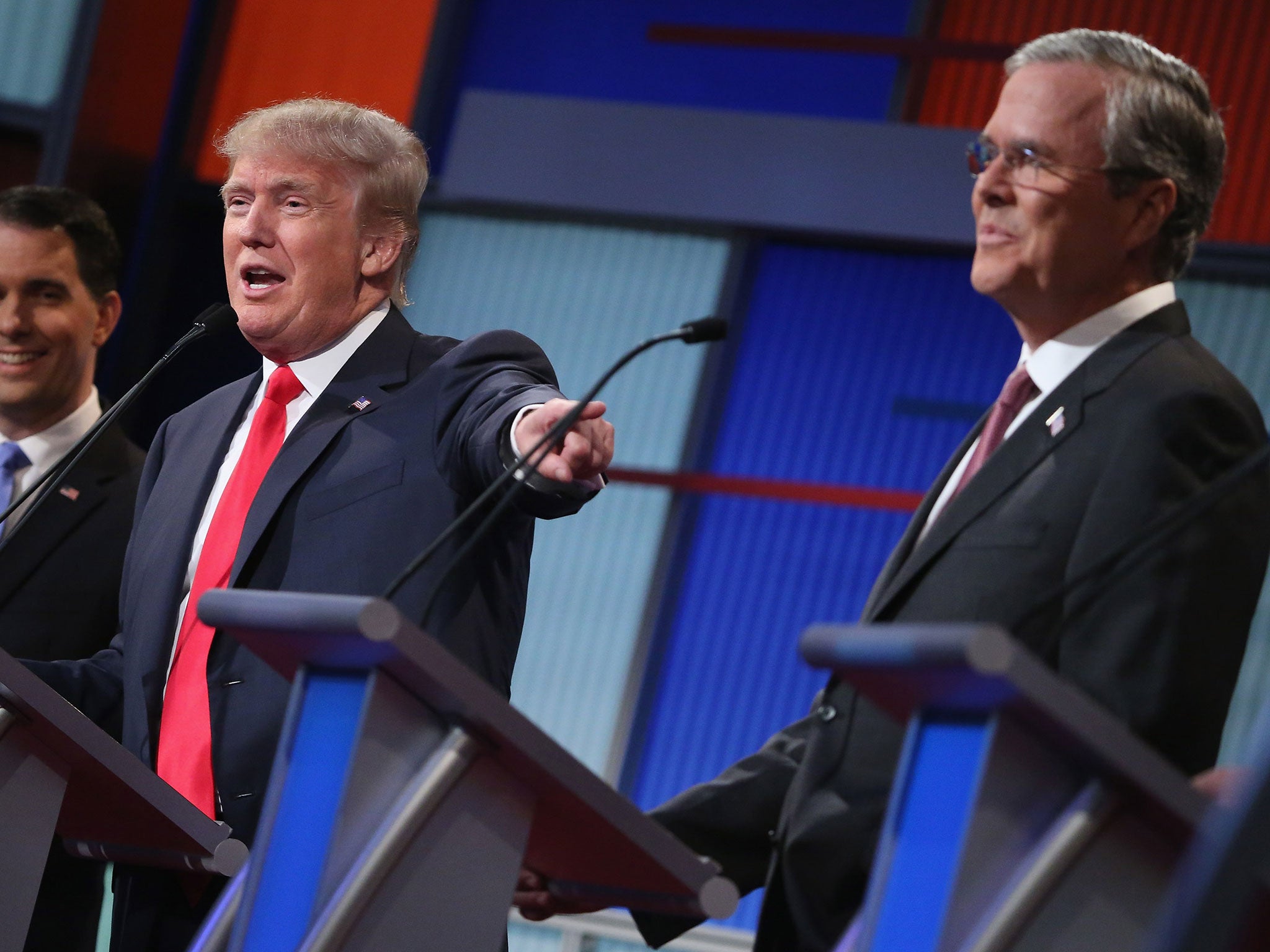 Republican presidential candidates (L-R) Wisconsin Gov. Scott Walker, Donald Trump and Jeb Bush participate in the first prime-time presidential debate hosted by FOX News and Facebook at the Quicken Loans Arena August 6, 2015 in Cleveland, Ohio