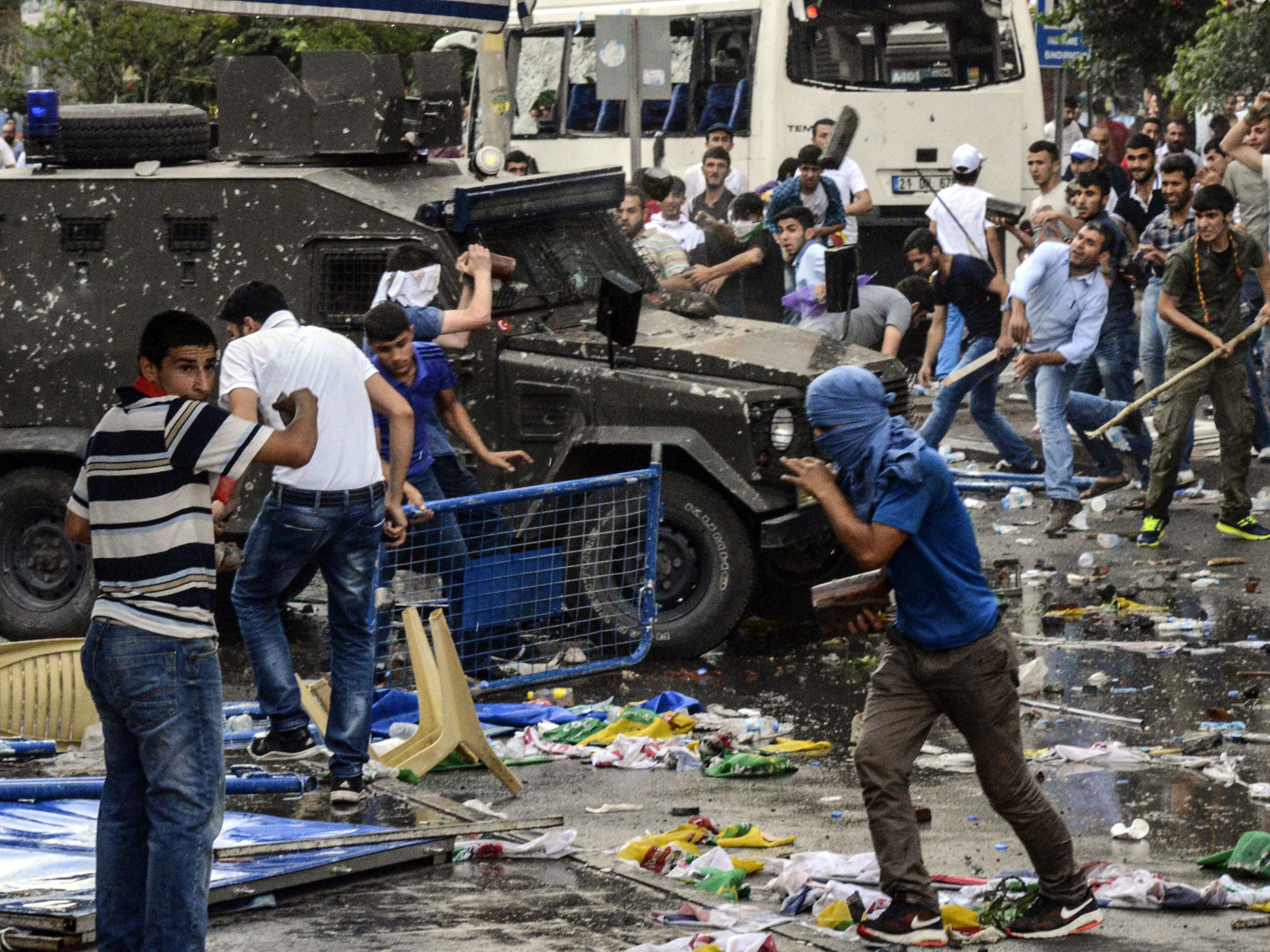 People clash with Turkish police after an explosion at a pro-Kurdish rally in Diyarbakir, where the journalists were detained