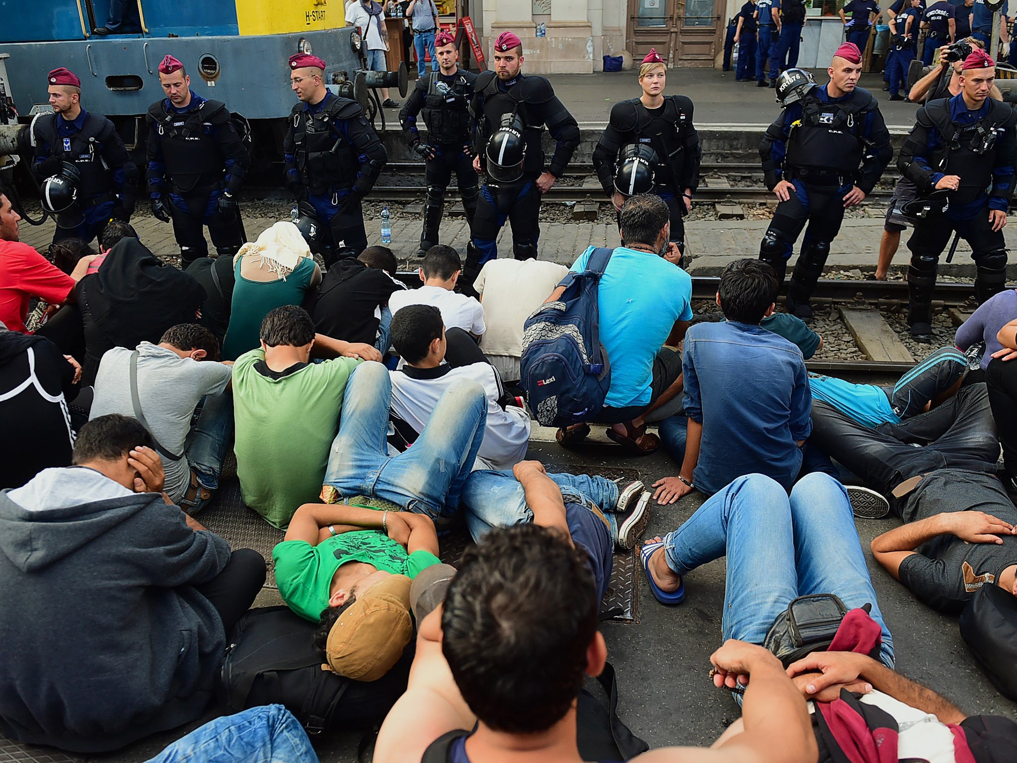 Riot police stand on the train track as they monitor migrants and refugees at the Keleti (eastern) railway station