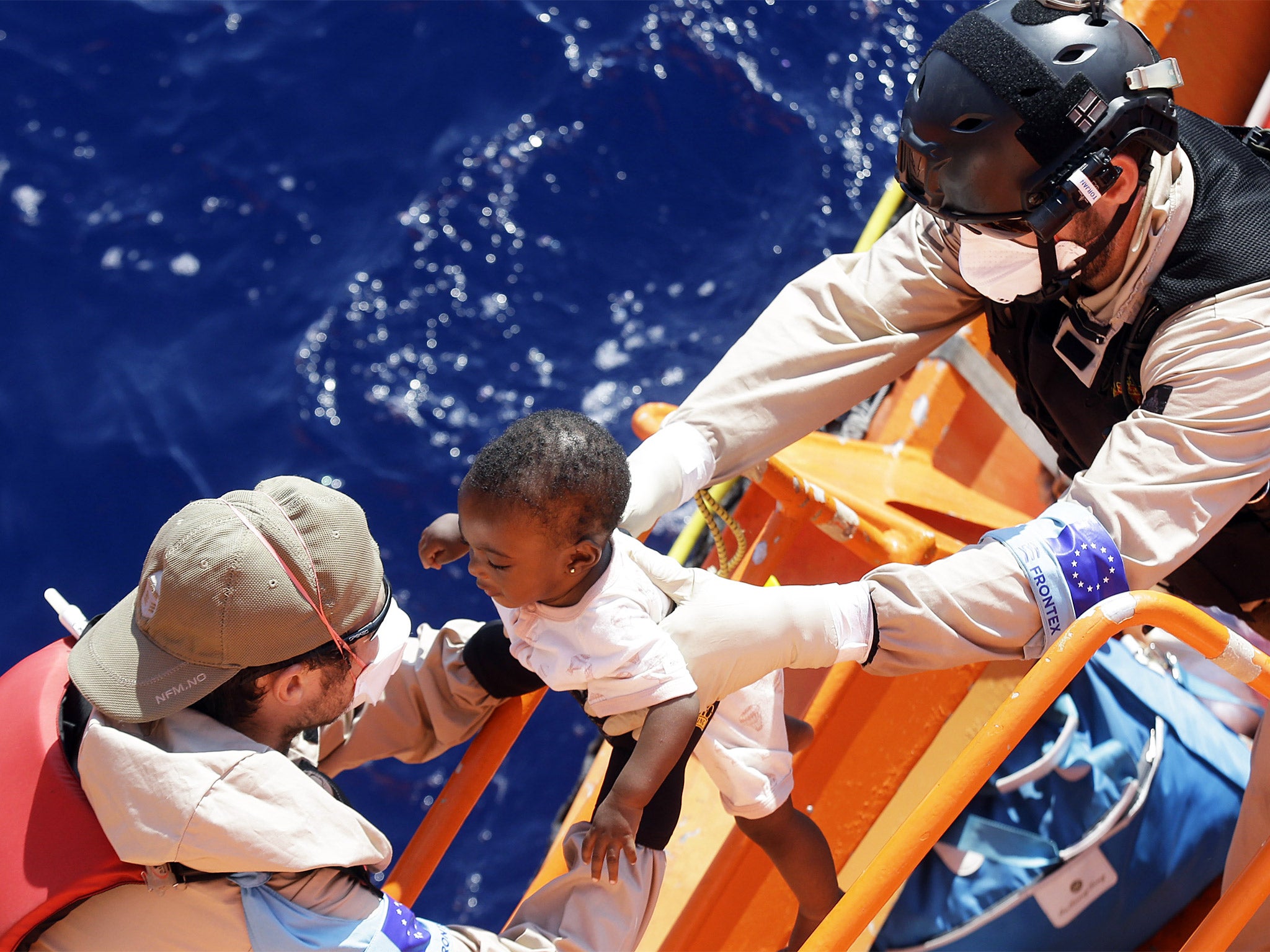 A baby is lifted on to the Norwegian vessel ‘Siem Pilot’ during a migrant search-and-rescue mission off the Libyan coast on Tuesday