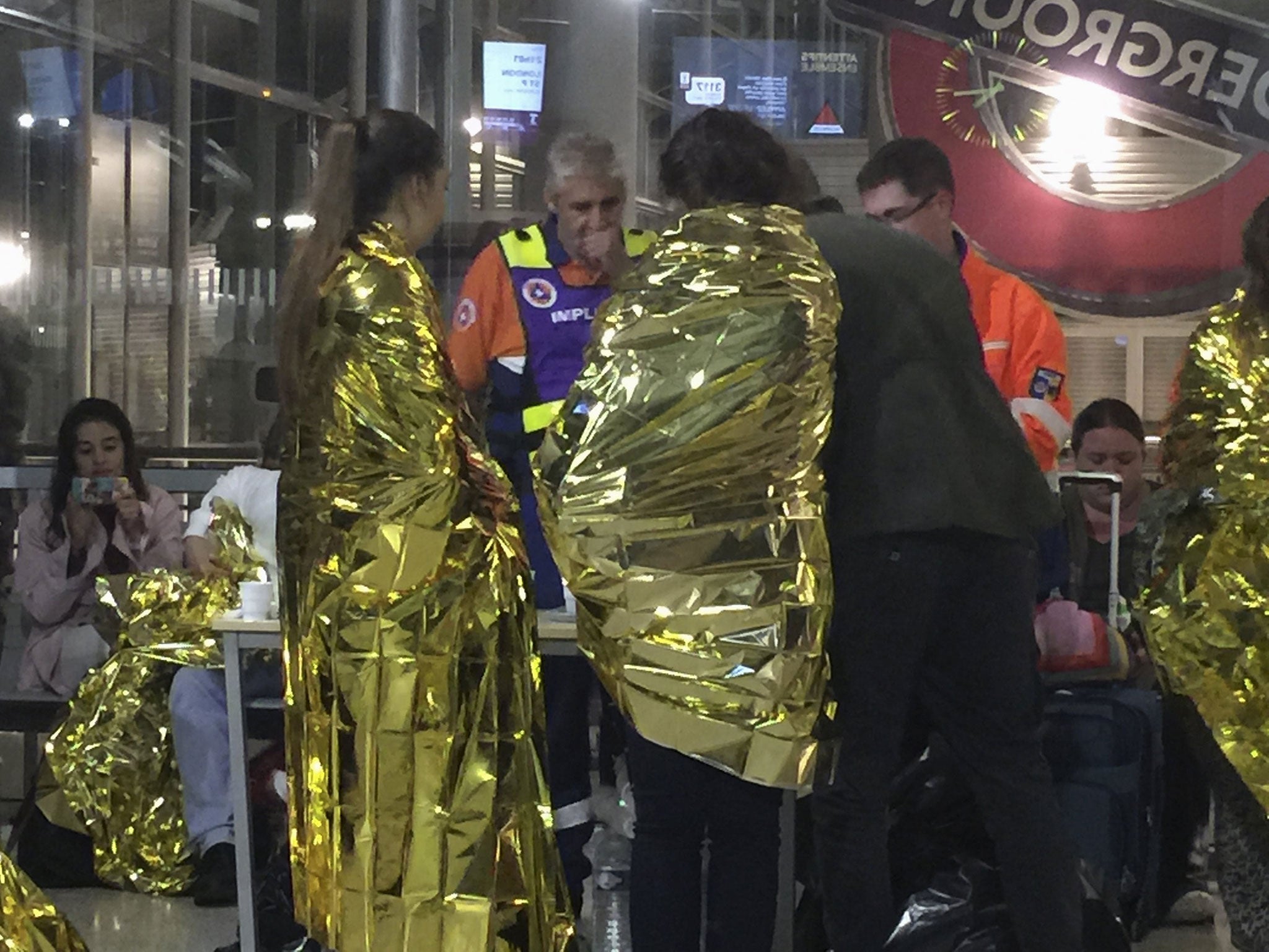 Passengers wrapped in thermal foil blankets given out by emergency services after their Eurostar train was stranded at Calais, after intruders were seen near the Eurotunnel on September 2, 2015