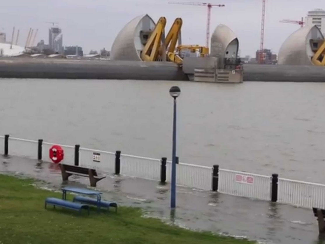 Water seeps over the banks of London’s river Thames