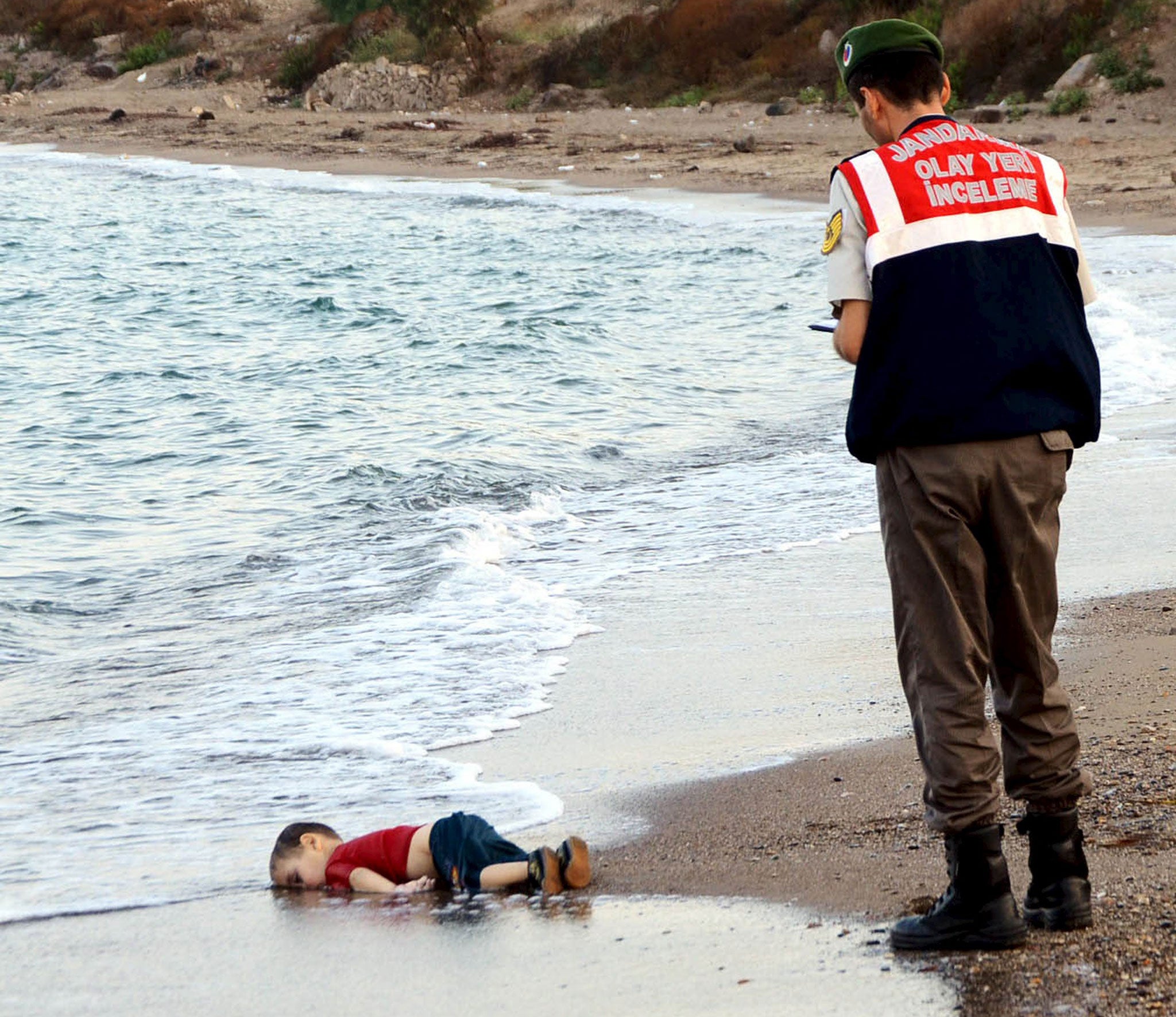 A young Syrian boy lies in the surf near Bodrum, Turkey