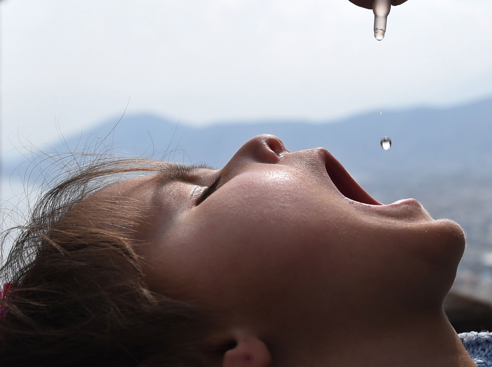 A child is administered with a polio vaccine