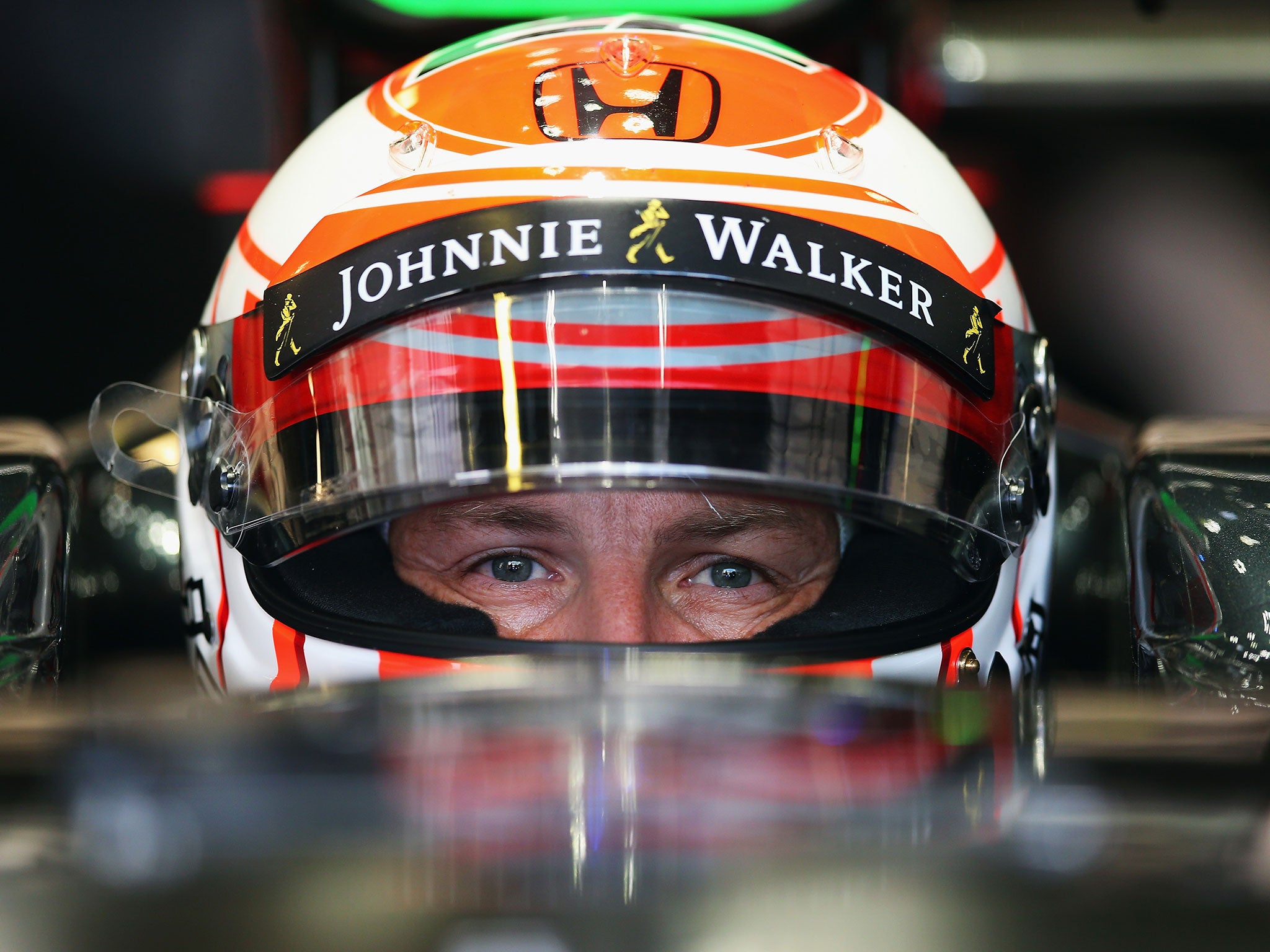 Jenson Button looks on from inside his McLaren cockpit