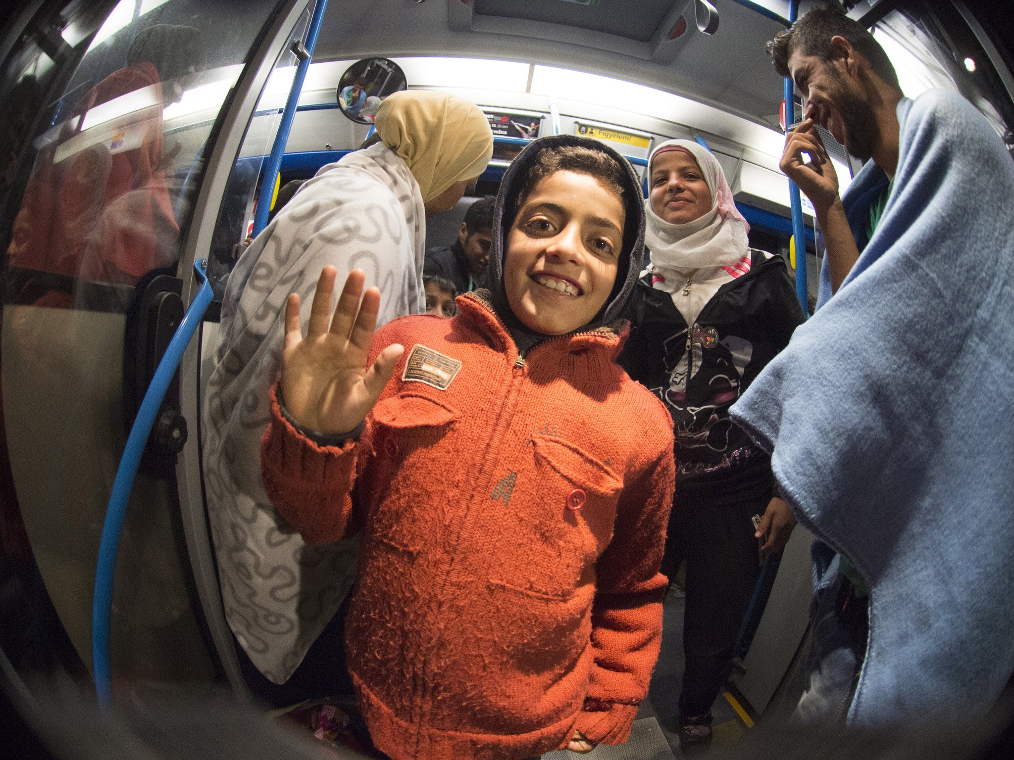 Refugees smile as they arrive at the village of Nickelsdorf in Austria