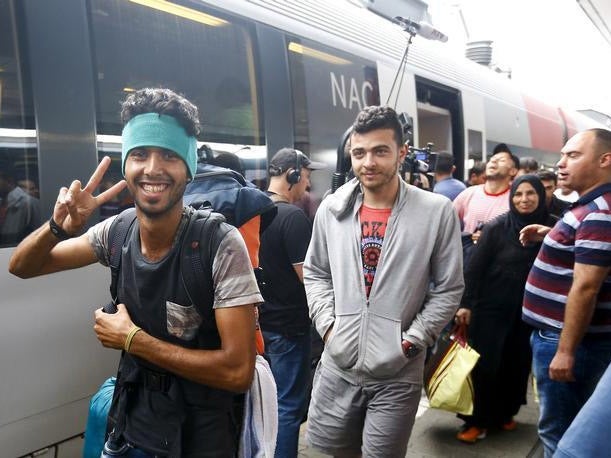 Migrants at a railway station in Vienna board a train to Germany