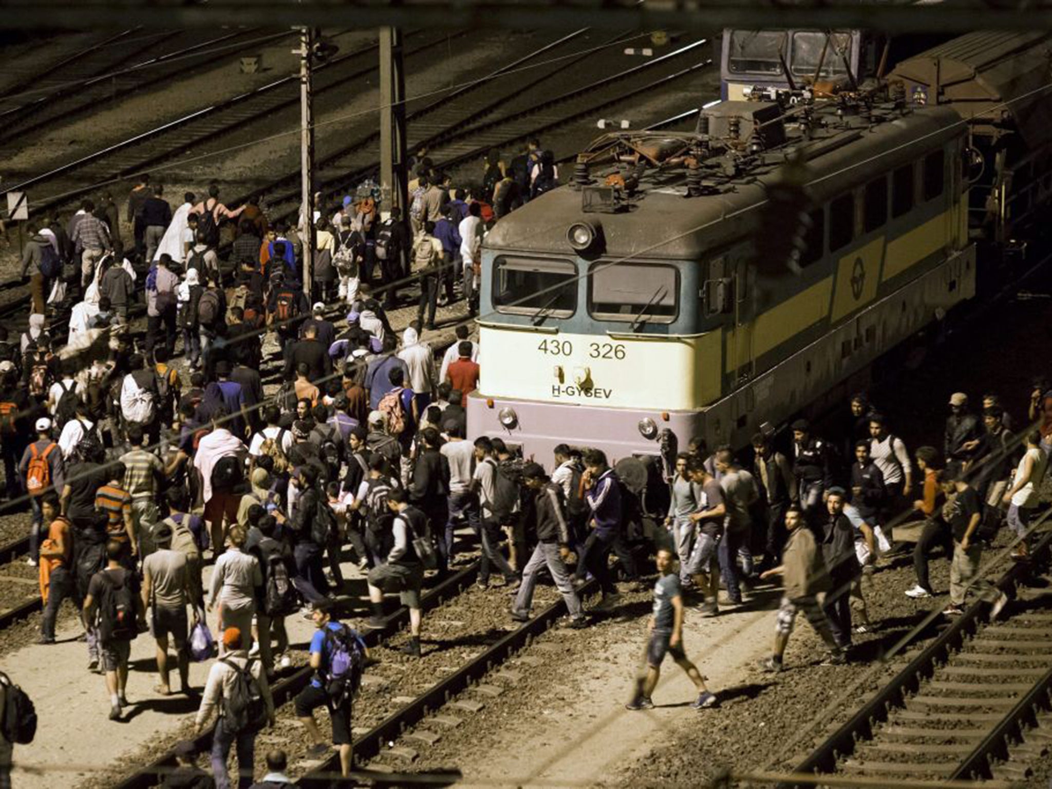 Refugees flood across the tracks at the Tatabanya Railway Station near Budapest in Hungary on their way to Austria