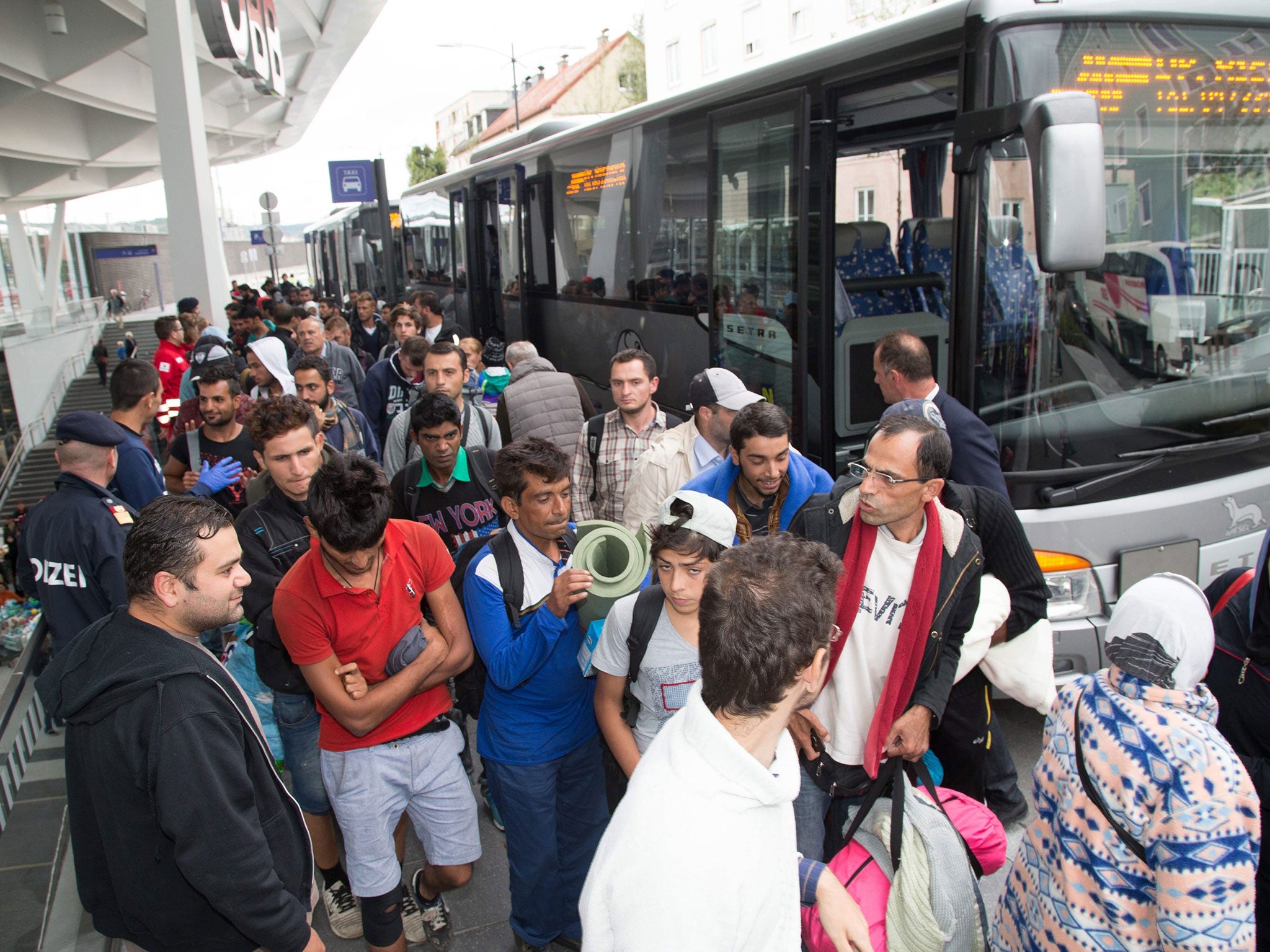 Refugees arrive at the train station in Salzburg, Austria, with many of them journeying onwards to Germany