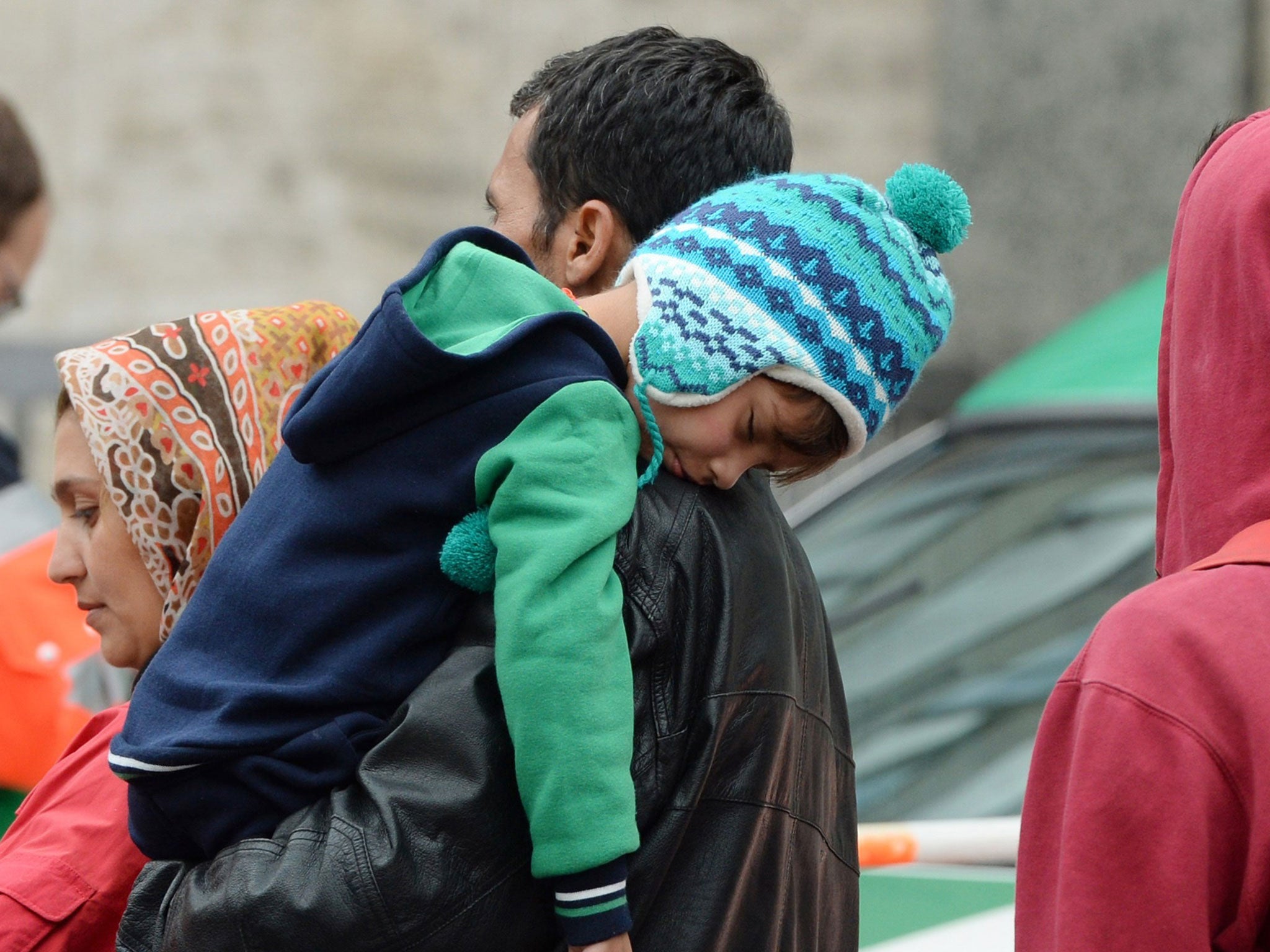 A family of refugees waits for a bus after their arrival at the main railway station in Munich on 6 September