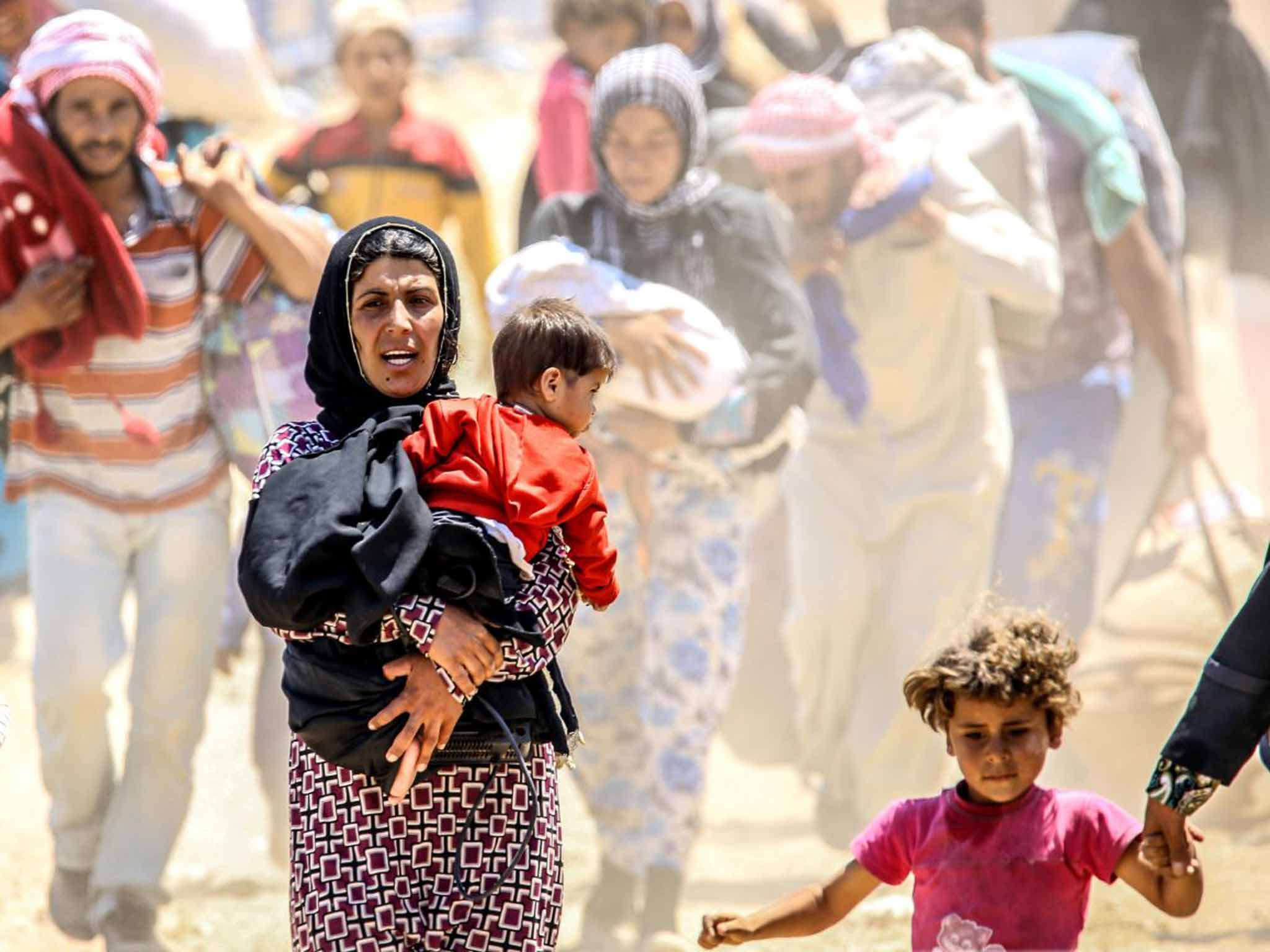 Syrians fleeing the clashes in the city of Tal Abyad and crossing into Turkey earlier this year