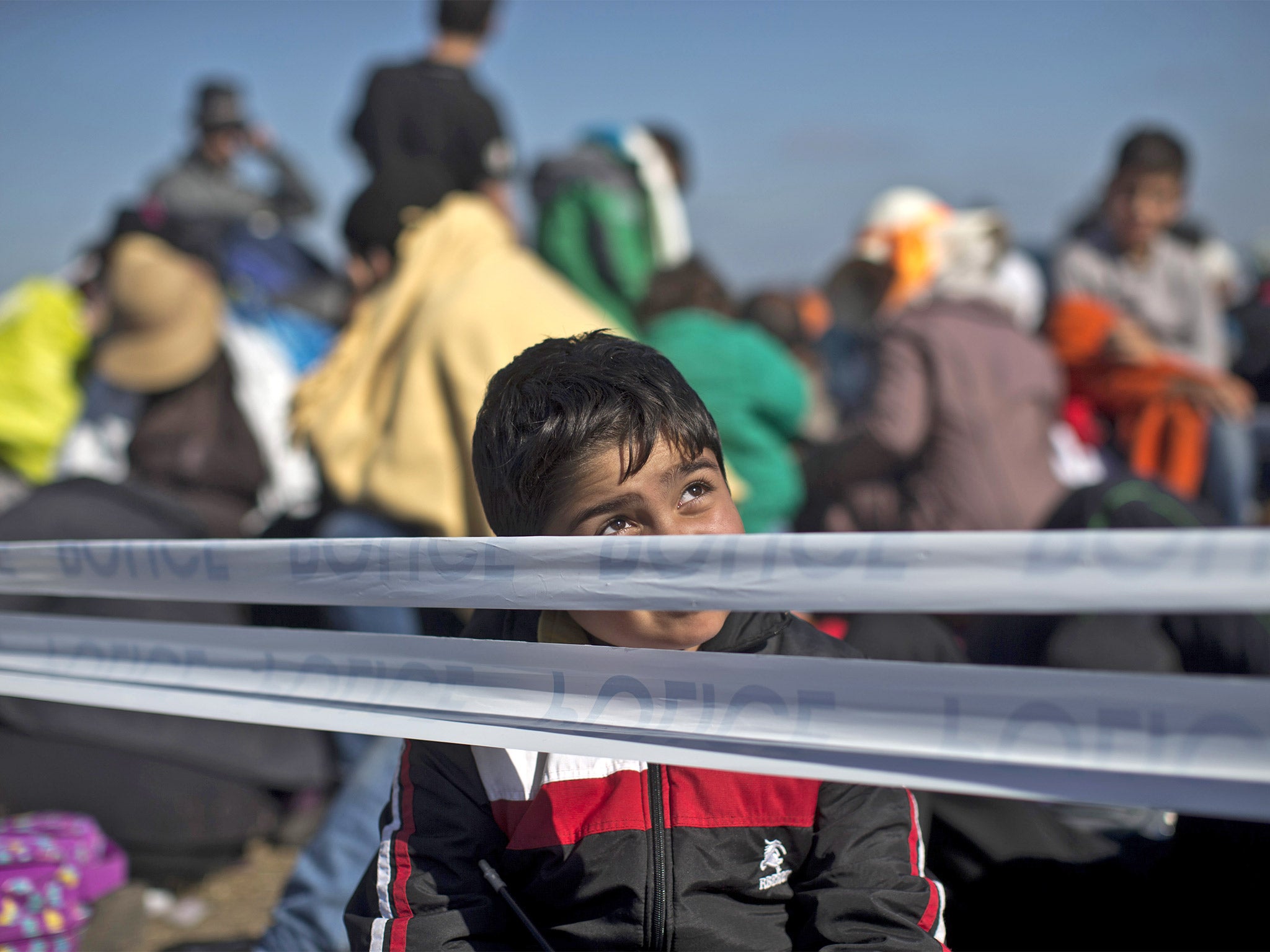 A child sits at a temporary holding camp for refugees close to the Serbian border in Roszke, Hungary