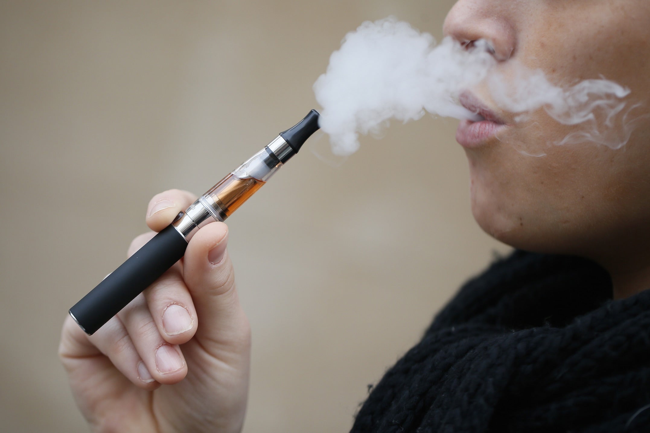 A person smokes an electronic cigarette filled with 'tobacco' in Paris.