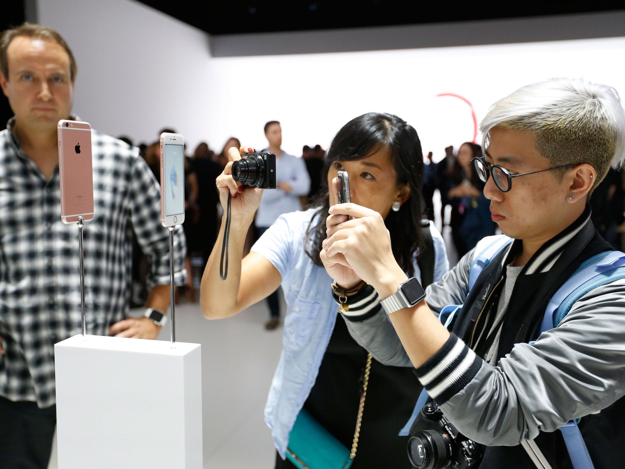 Members of the media photograph the new apple iPhone 6s in rose gold after an Apple special event at Bill Graham Civic Auditorium September 9, 2015 in San Francisco, California