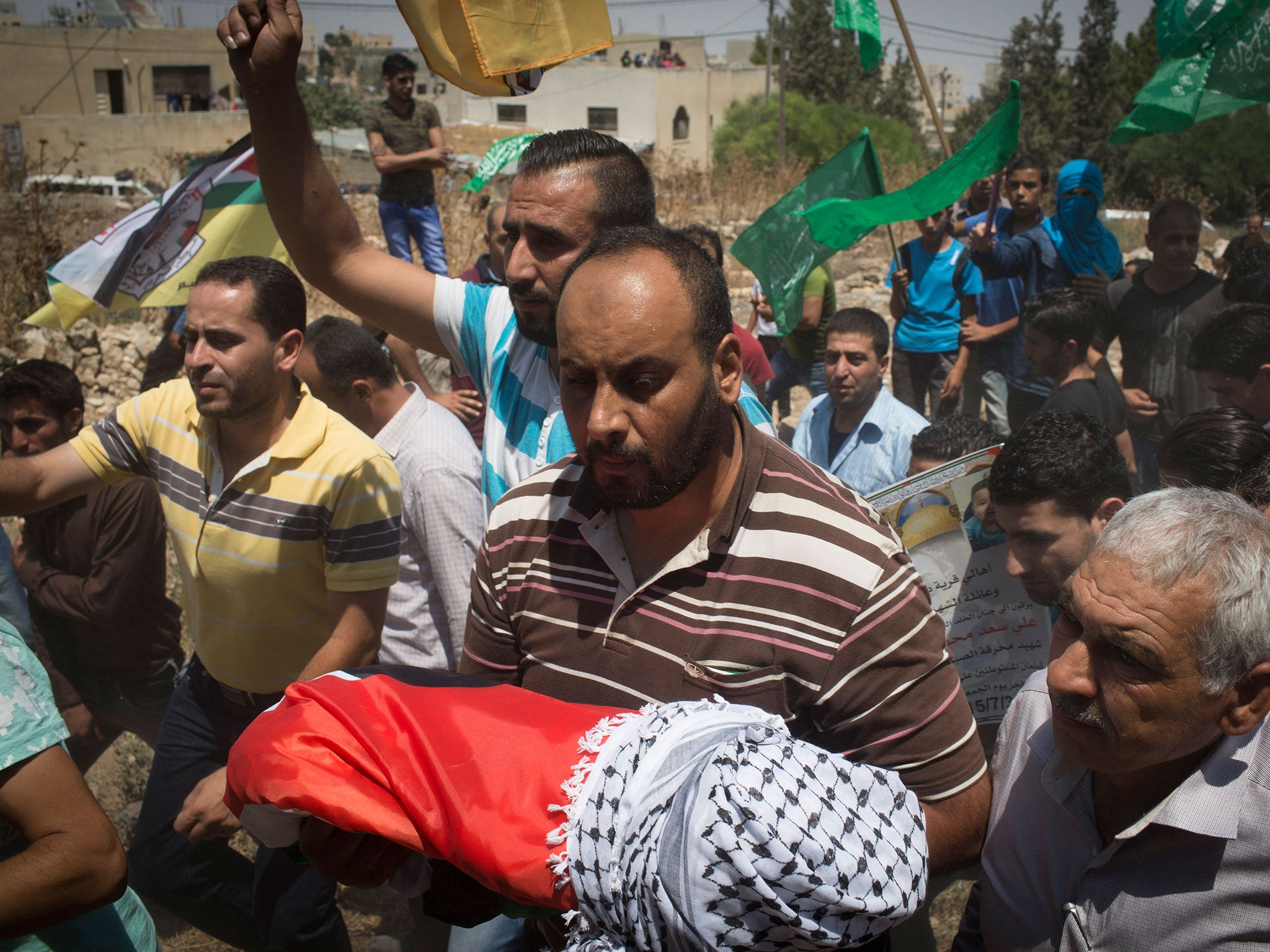 Surrounded by his relatives, the body of the 18 month old baby Ali Saad-Dawabsheh is carried during his funeral