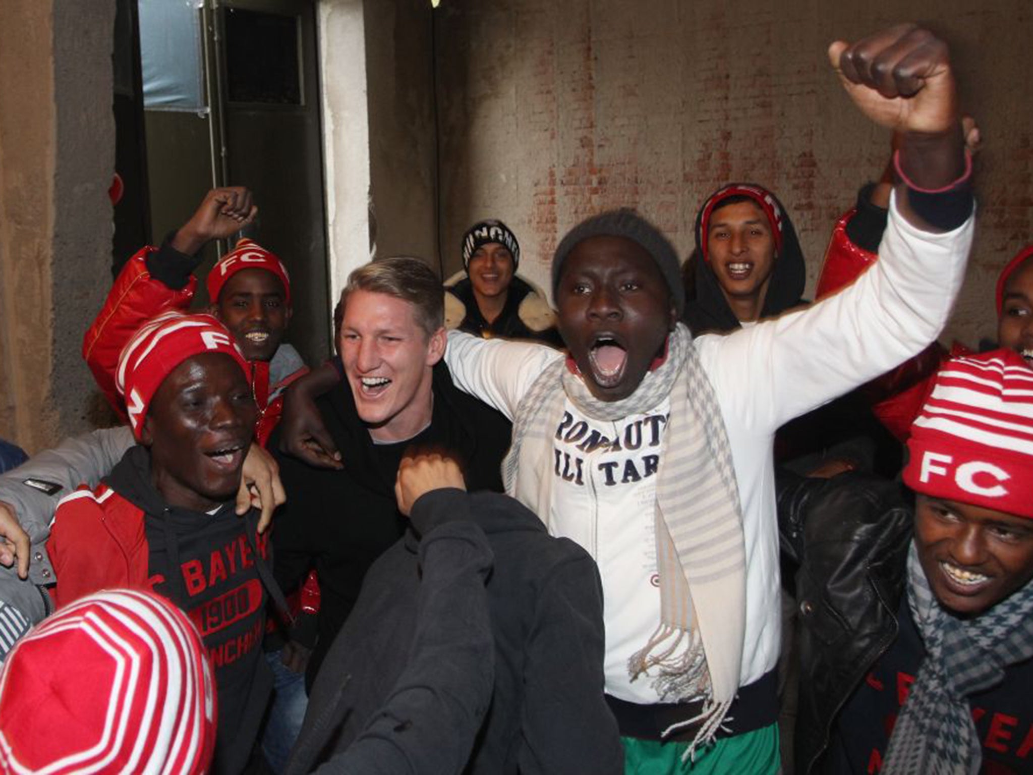 The then Bayern Munich midfielder Bastian Schweinsteiger in an army barracks in Germany after the club donated sportswear to refugees who were staying there last year