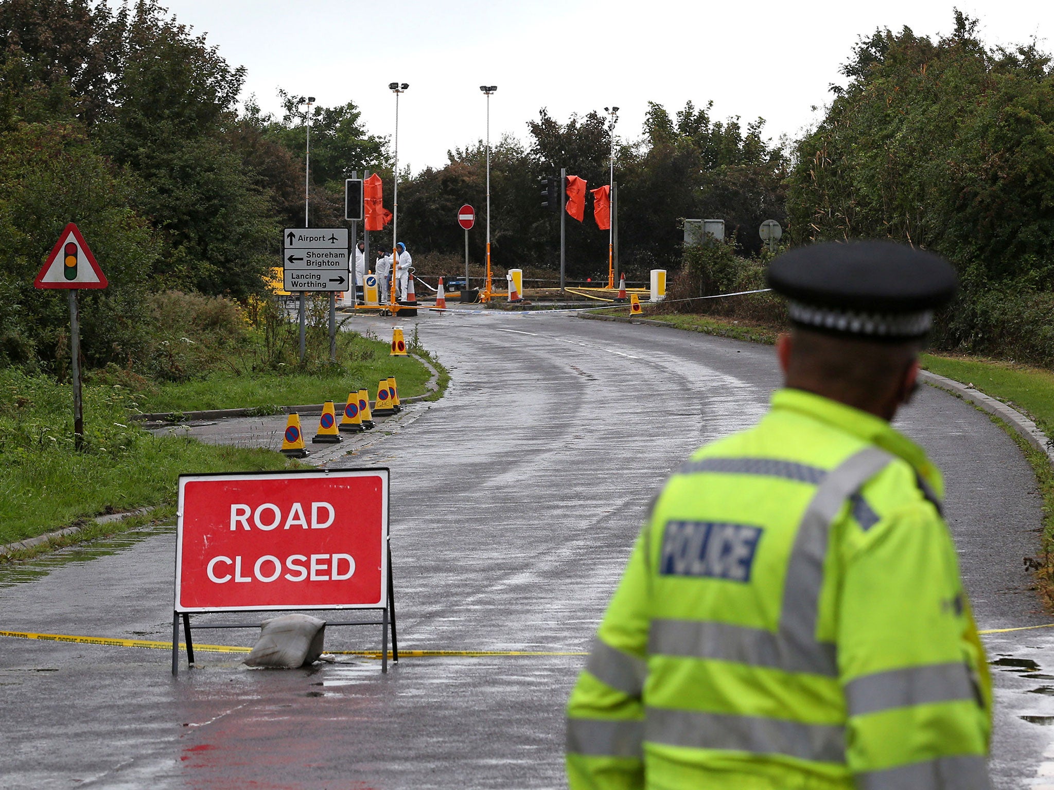 A policeman looks to the A27 road near where the Hawker Hunter fighter jet crashed