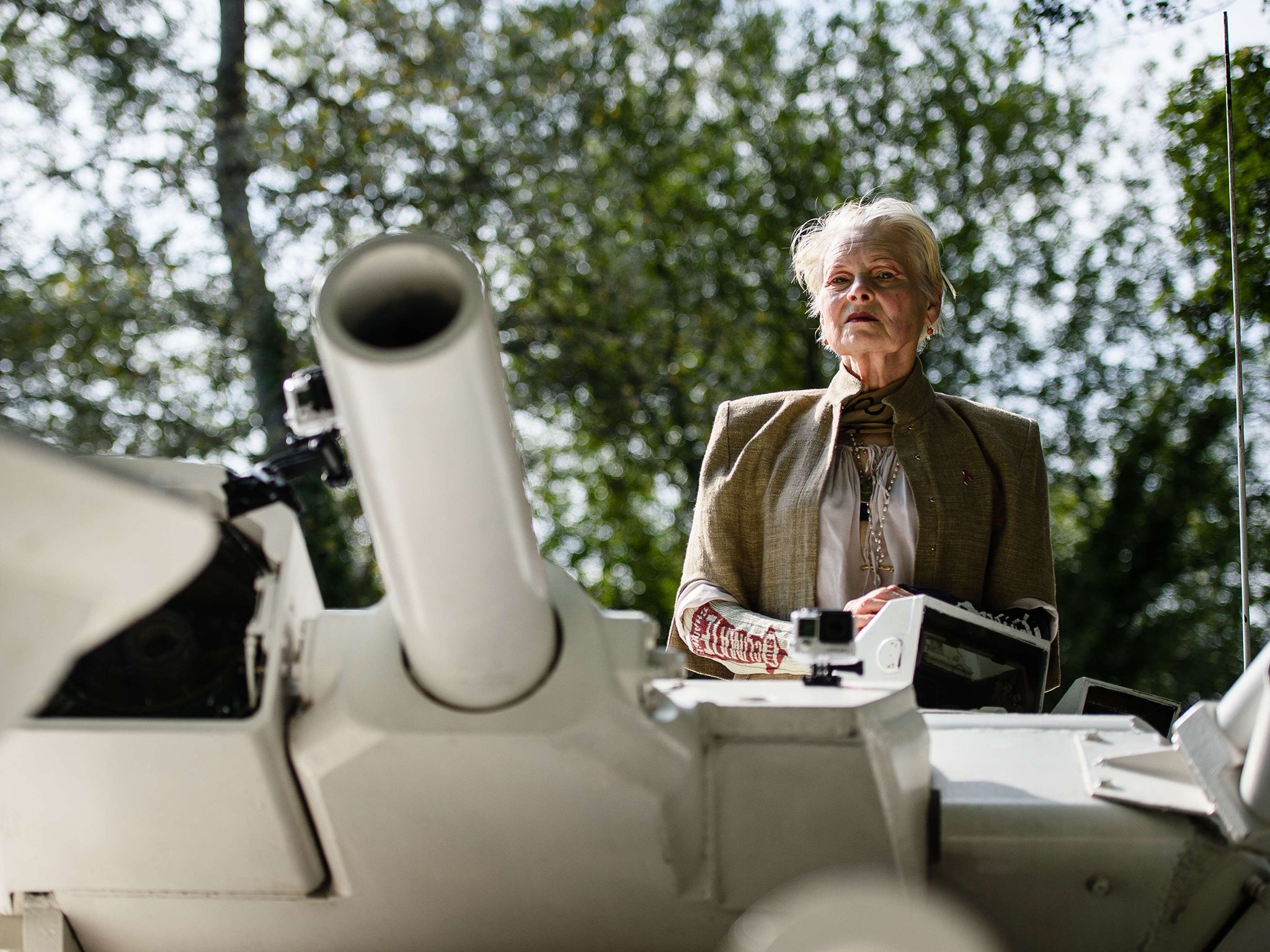 Vivienne Westwood rides on top of an armored personnel carrier (APC)