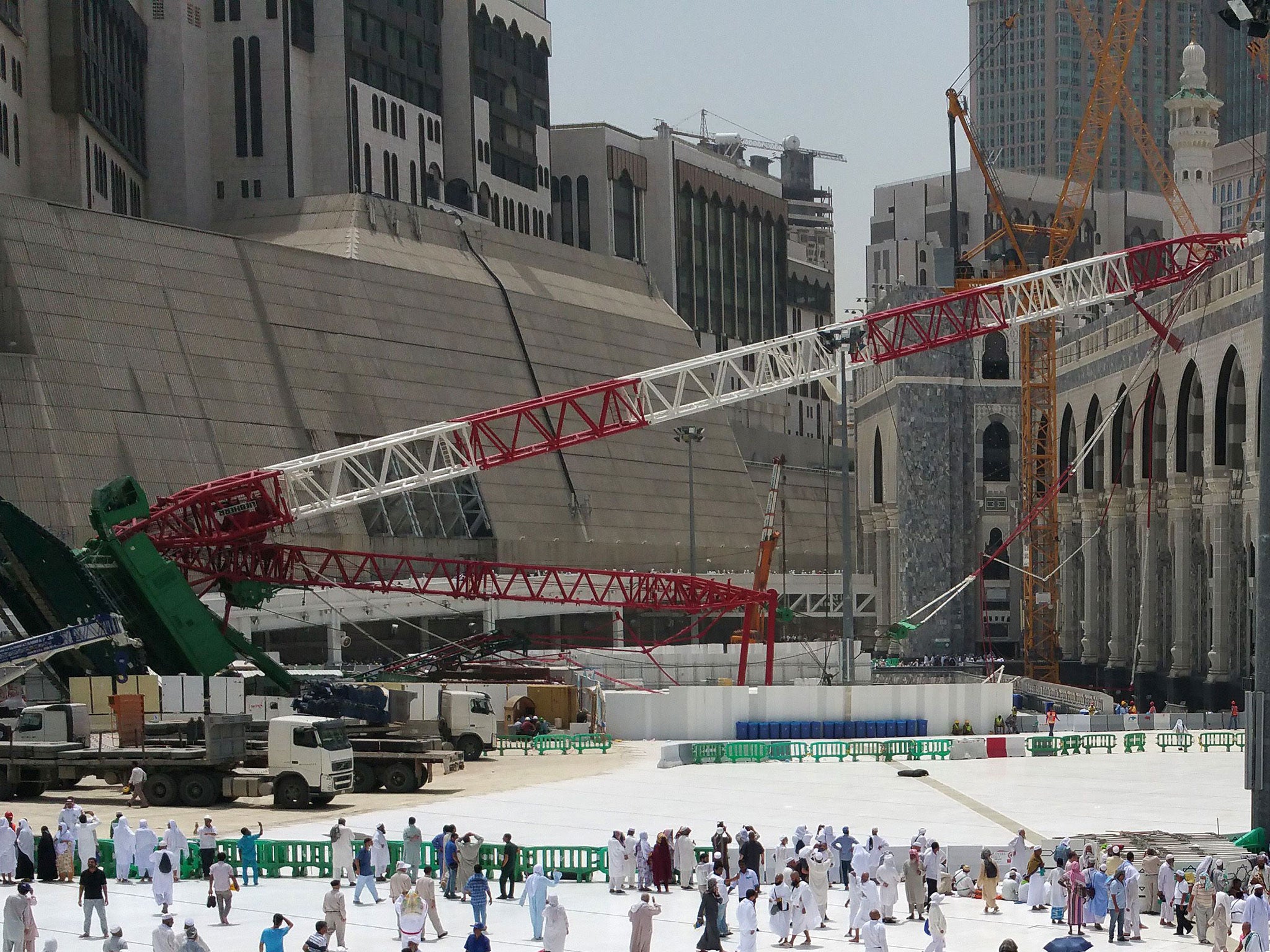 Muslim pilgrims walk past the crane that collapsed at the Grand Mosque in Saudi Arabia's holy Muslim city of Mecca