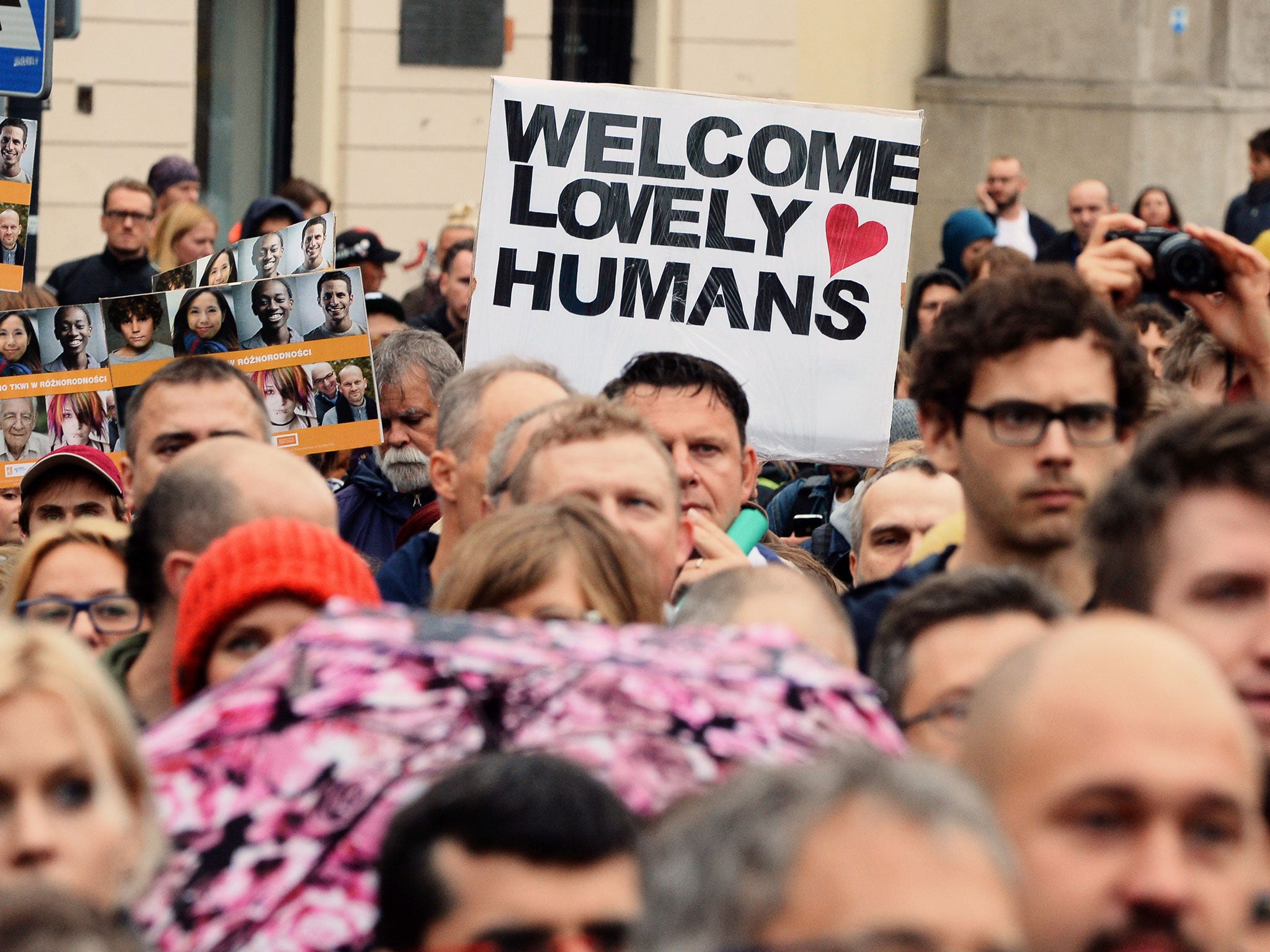 Protesters gather in Warsaw 'Welcome lovely humans' in Warsaw (Image: AFP)