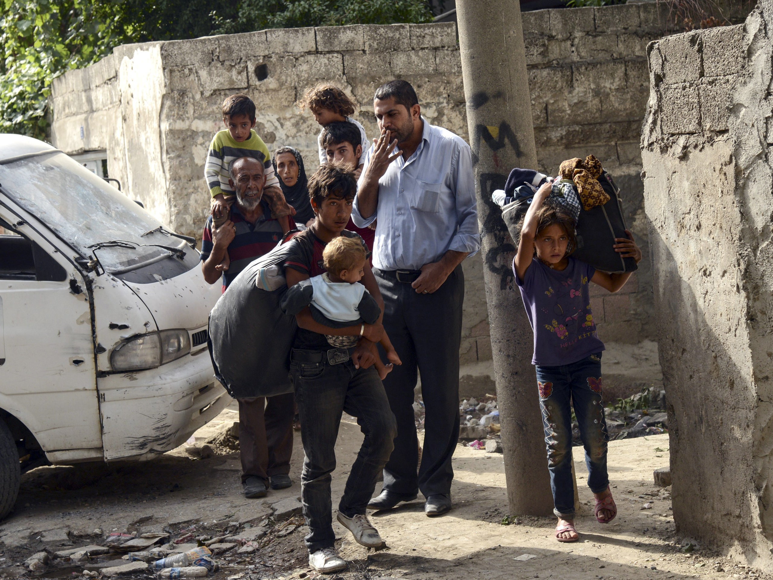 People go out into a street, after a curfew was lifted, following clashes between Turkish forces and militants of the Kurdistan Workers' Party (PKK) in the Kurdish-majority city of Cizre, in southeastern Turkey, on September 12, 2015.