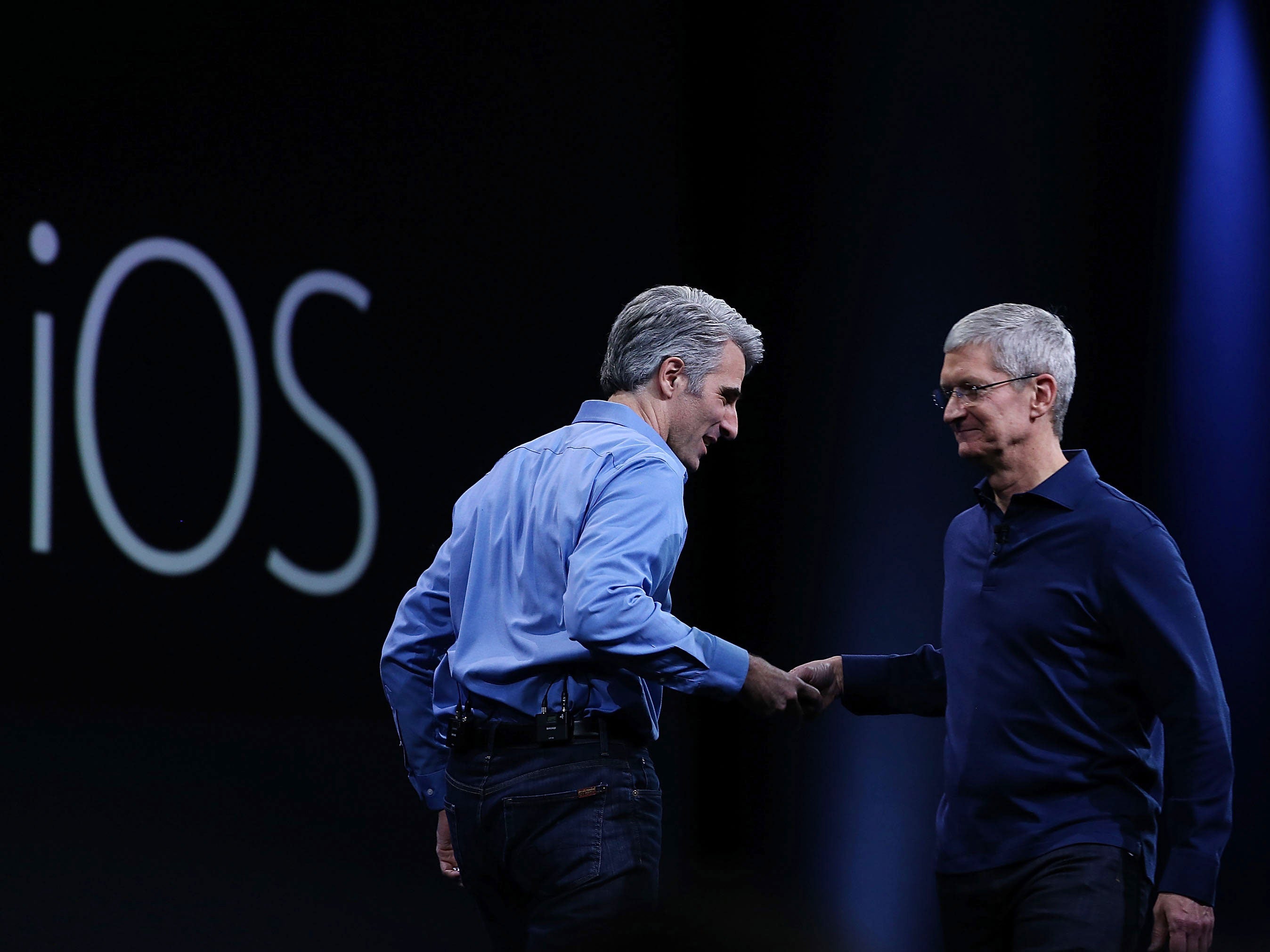 Apple senior vice president of Software Engineering, Craig Federighi (L), shakes hands with Apple CEO Tim Cook during the Apple WWDC on June 8, 2015 in San Francisco, California