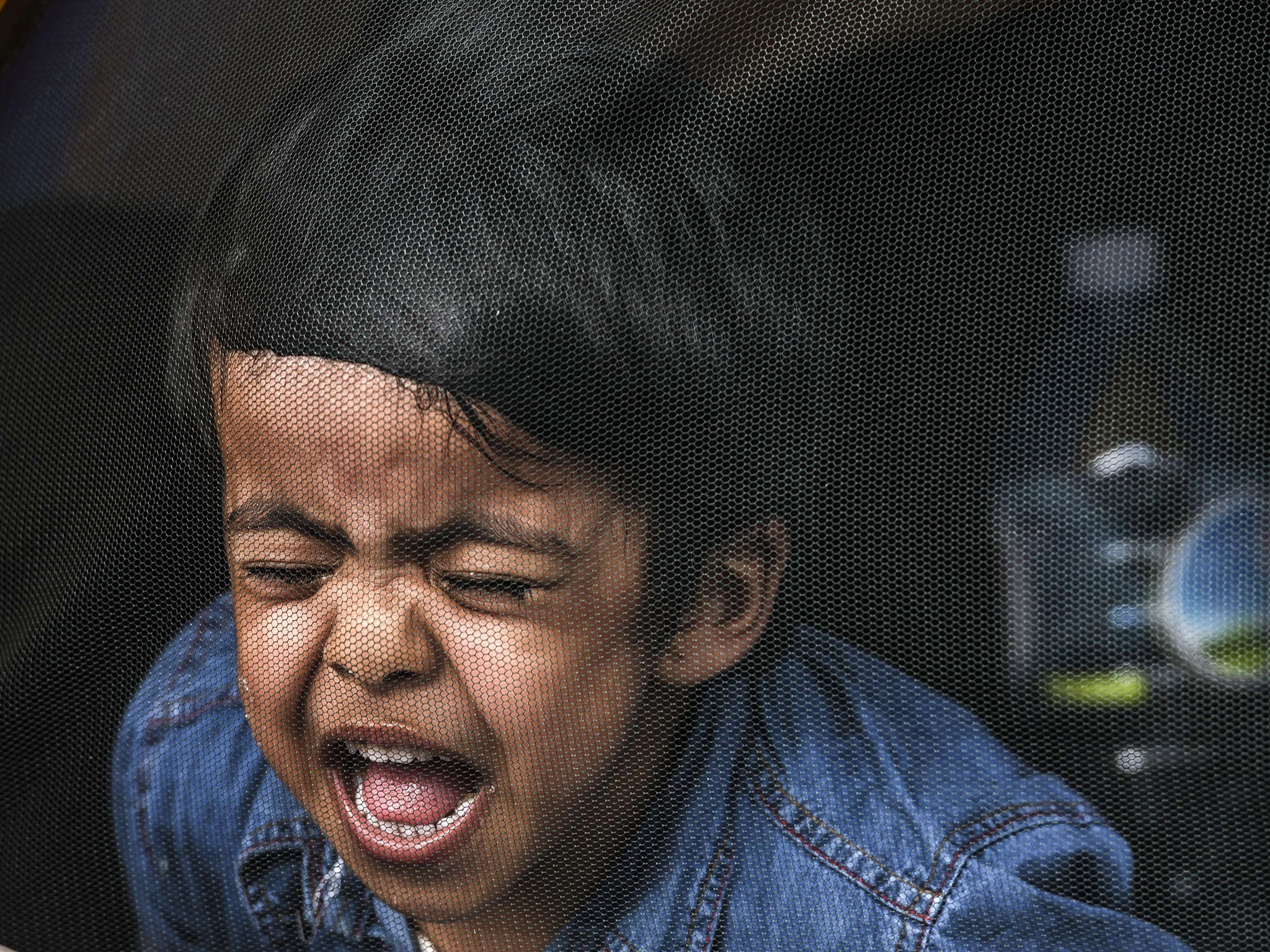 A child cries inside a tent at a makeshift refugee camp at the Hungarian border with Serbia near the town of Horgos