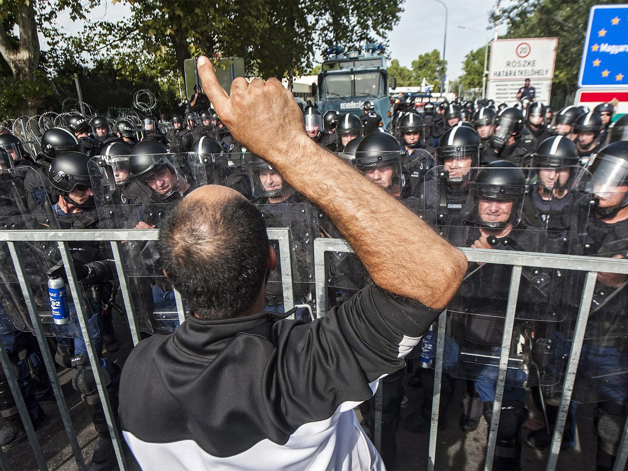 A refugees shouts in front of a police blockade at the Horgos 2 border station